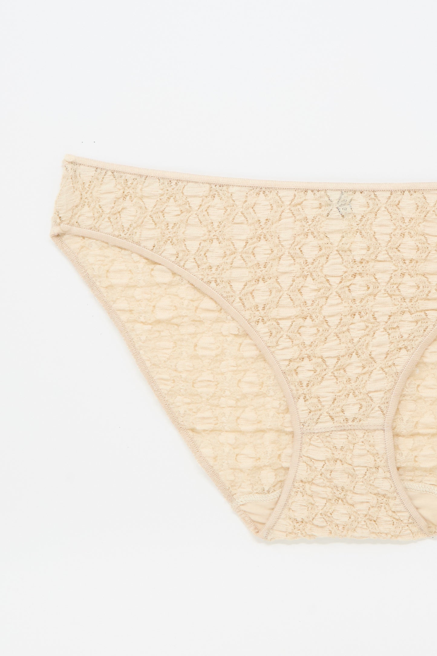 The Crescent Pants in Dylan Beige by Baserange, a beige cotton lace low-rise women's brief, is displayed flat on a white background, showing the front and partial side.