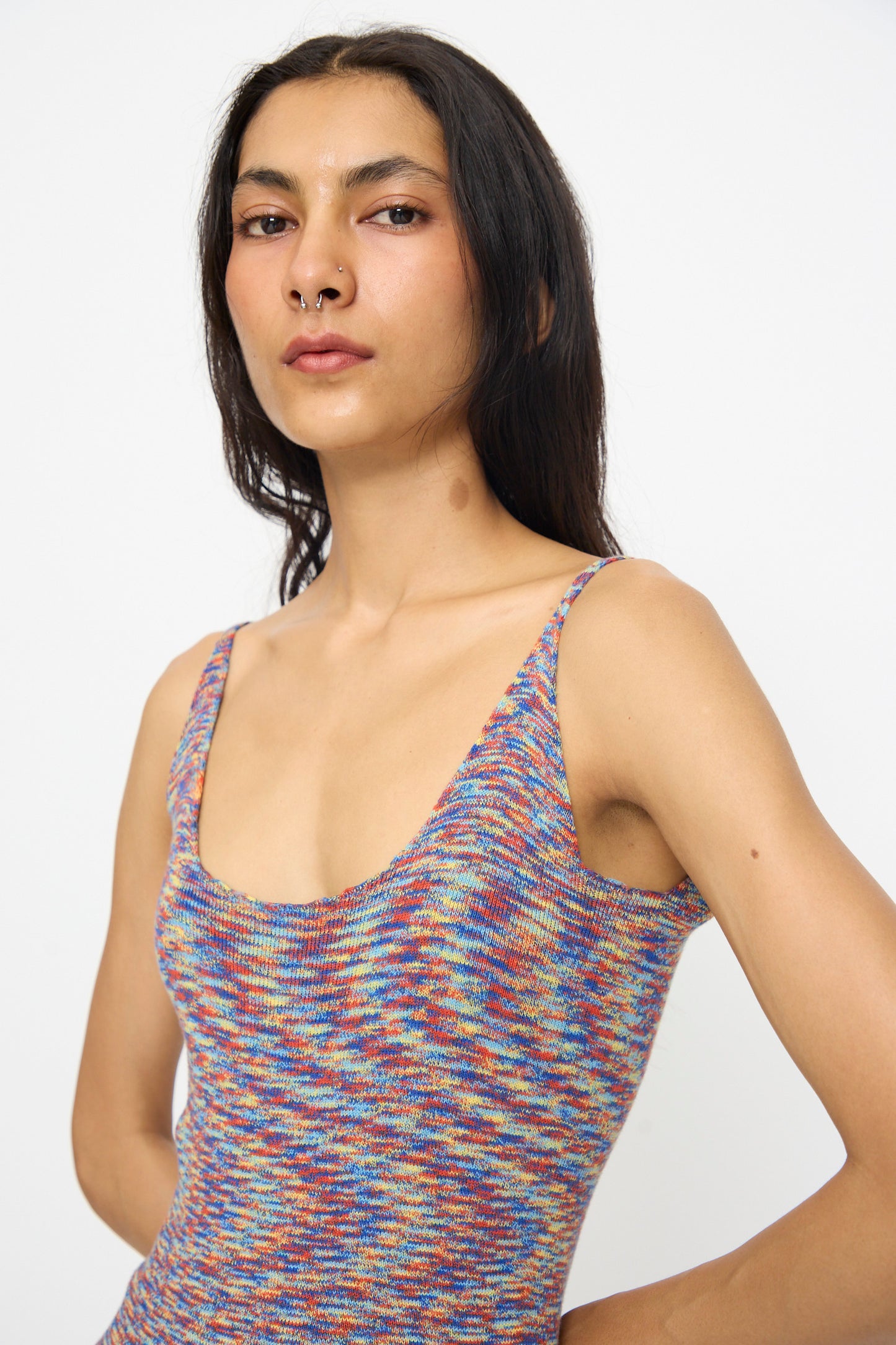 A person with long dark hair wears Baserange's Flute Dress in Multicolored, slim fit, made of cotton, standing against a plain white background and looking at the camera with a neutral expression.
