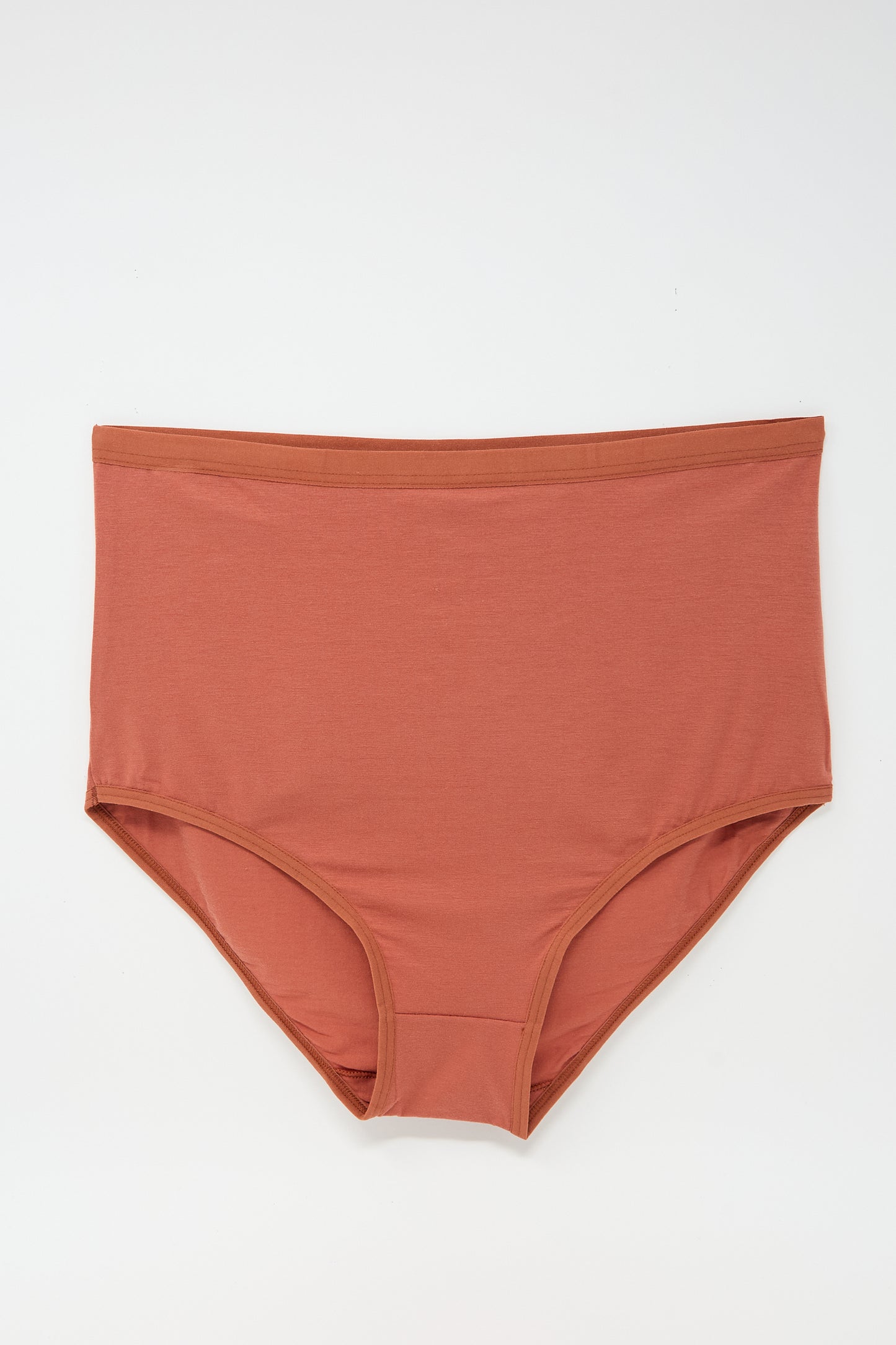 A pair of Baserange Highwaist Bell Pants in Burned Red with elastic trim displayed flat against a white background.