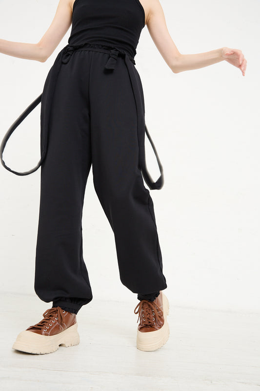A person wearing the Baserange Italian Fleece Route Sweatpant in Black and tan platform sneakers.