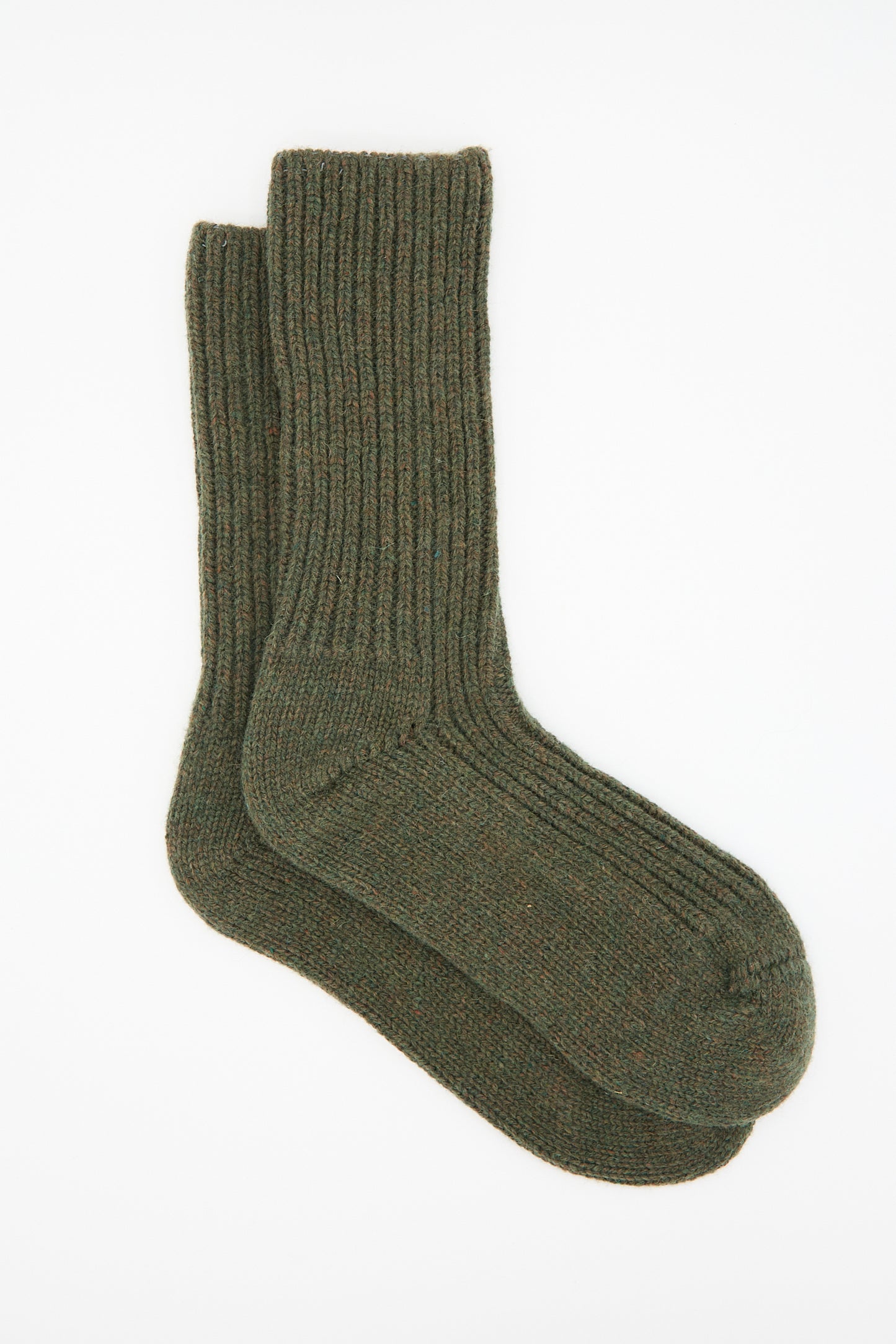 The Baserange Mea Sock in Foret, a pair of dark green, ribbed-knit socks made in France, is laid out flat on a white surface.