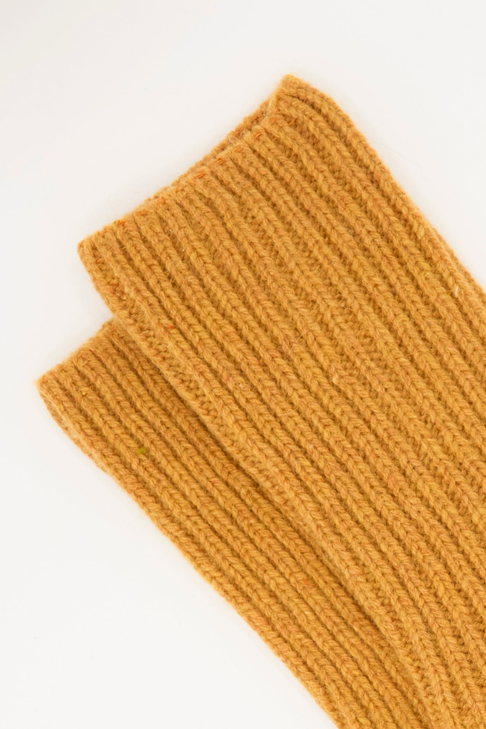 Close-up of two ribbed, Clair Orange knit sections from Baserange's Mea Socks, overlapping on a white background.