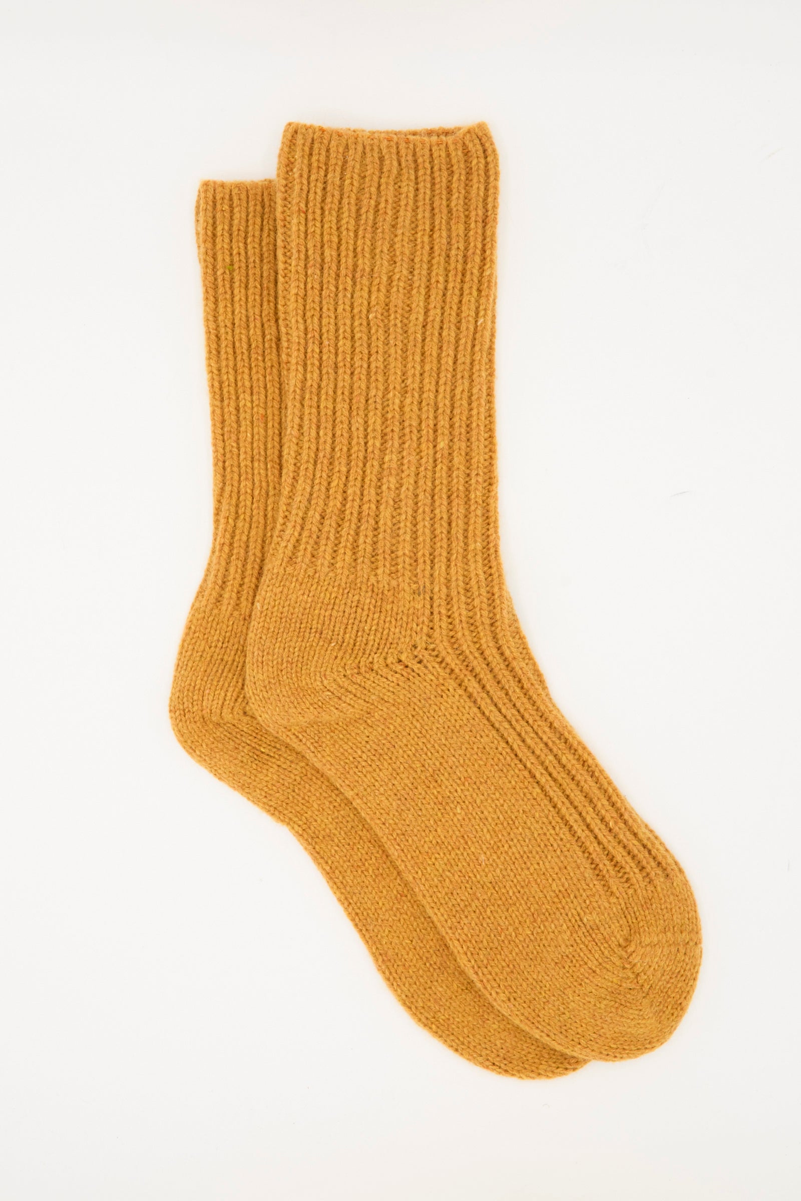 A pair of Baserange Mea Socks in Clair Orange, ribbed wool, made in France, laid flat on a white background.