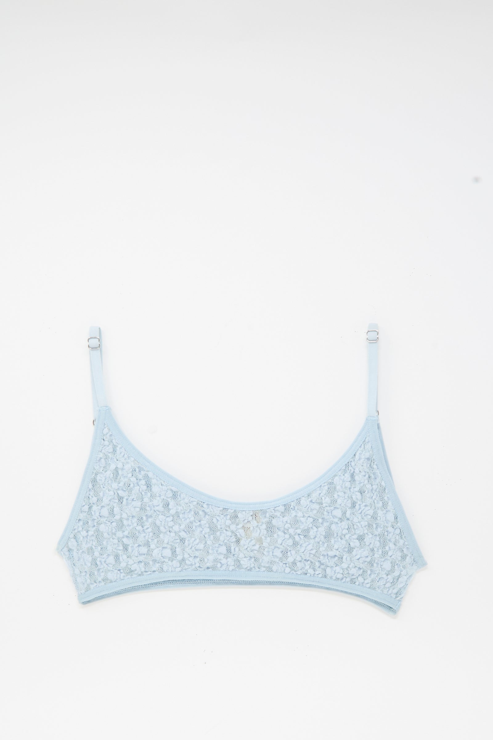 The Baserange Musial Bra in Dona Blue, featuring adjustable straps and delicate lace, is laid flat on a white background.