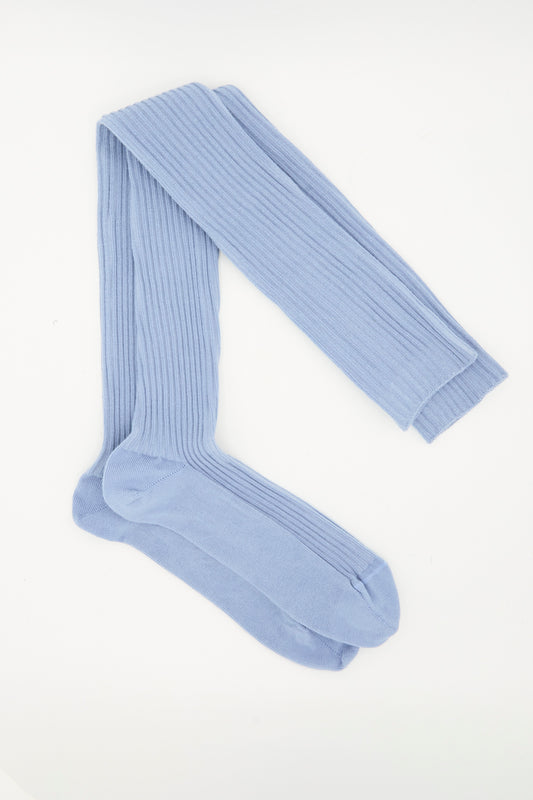 A pair of Baserange Overknee Socks in Korai Blue, made from a ribbed cotton blend, laid flat on a white background.