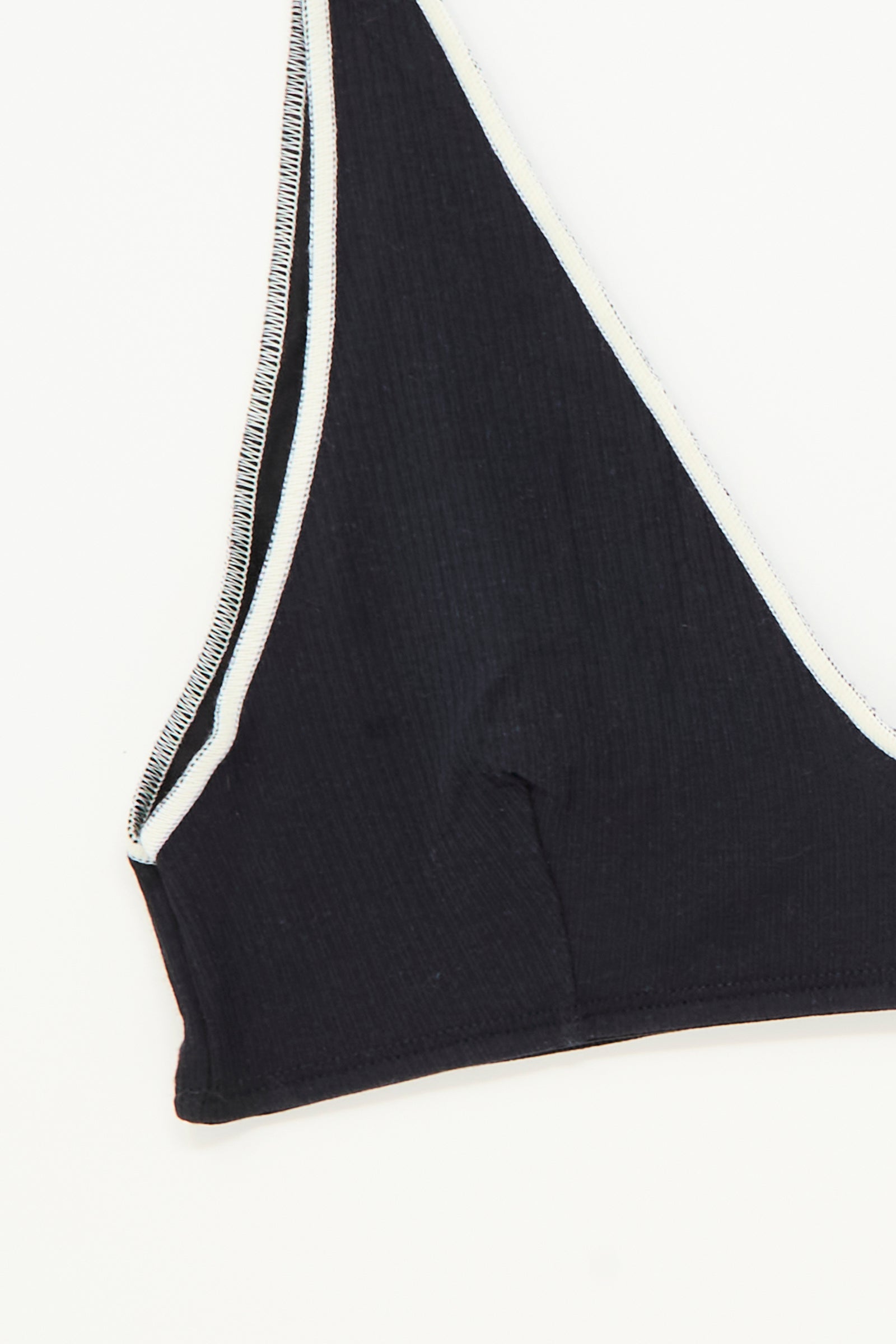 Close-up of the Pam Bra in Murano Navy by Baserange, featuring a black ribbed v-neck design with white trim against a white background.