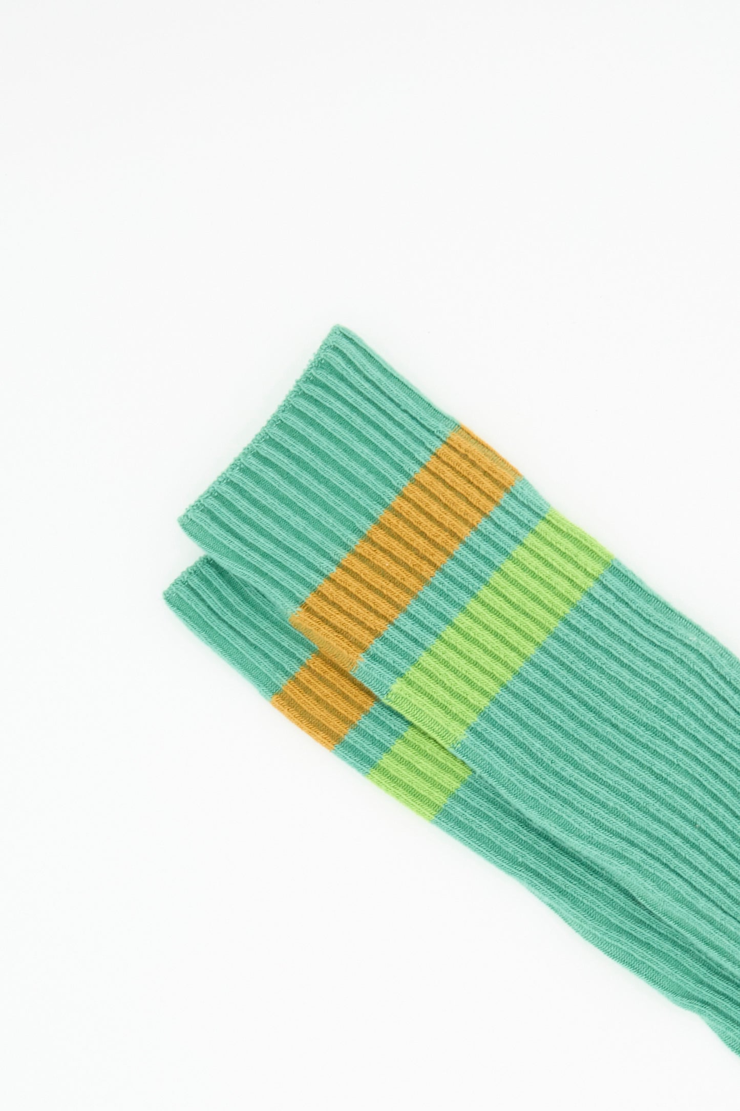 Two Baserange Race Knee Socks in Orbit Green, crafted from cotton rib and featuring yellow and light green stripes near the top, arranged parallel on a white background; made in France.