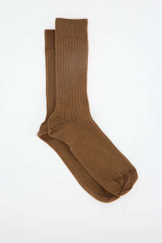 A pair of Baserange Rib Overankle Socks in Nocciola Brown, crafted in France from premium organic cotton, laid flat on a white background.