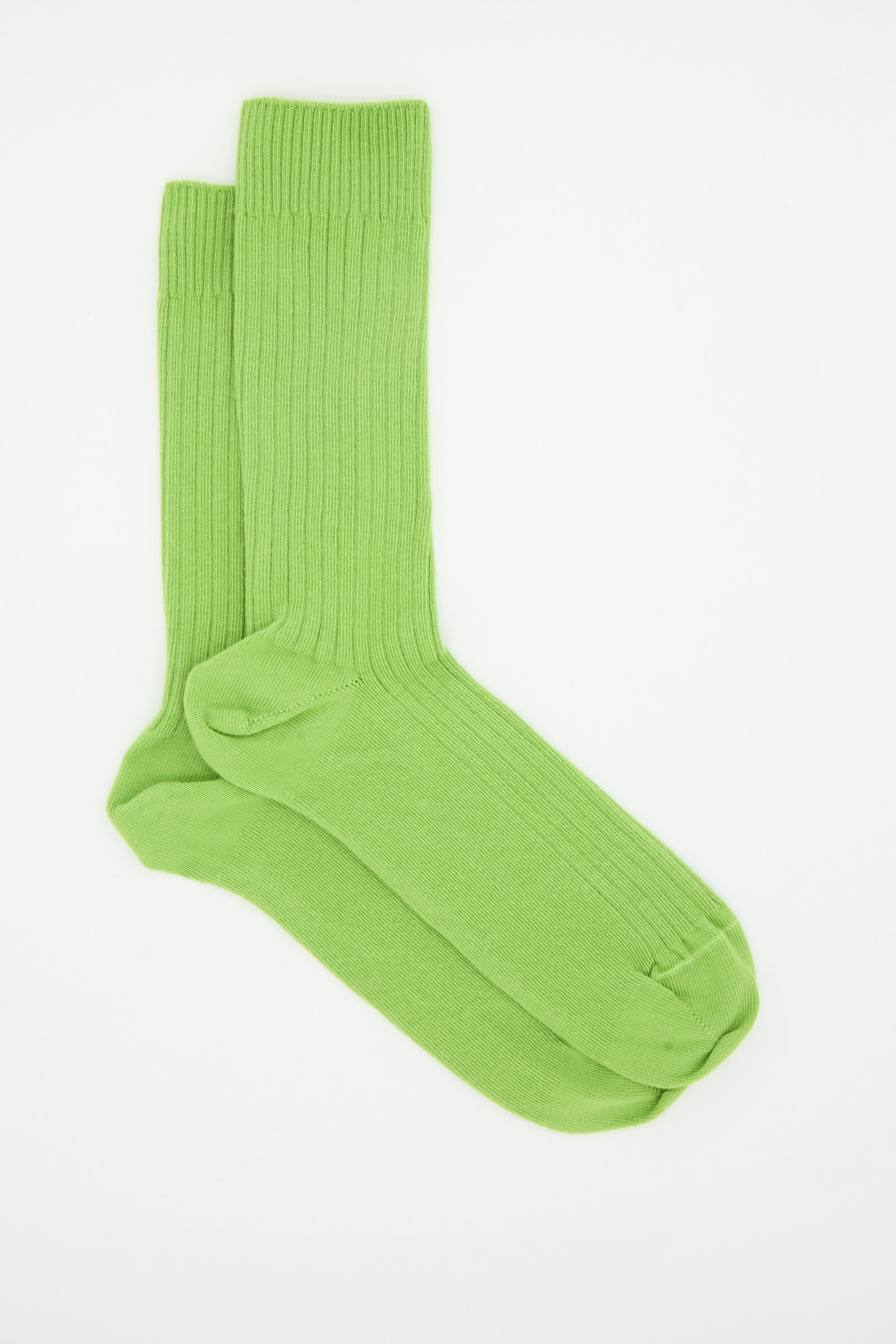 A pair of Baserange Rib Overankle Socks in Spiral Green, crafted from organic cotton, is neatly arranged on a plain white background.