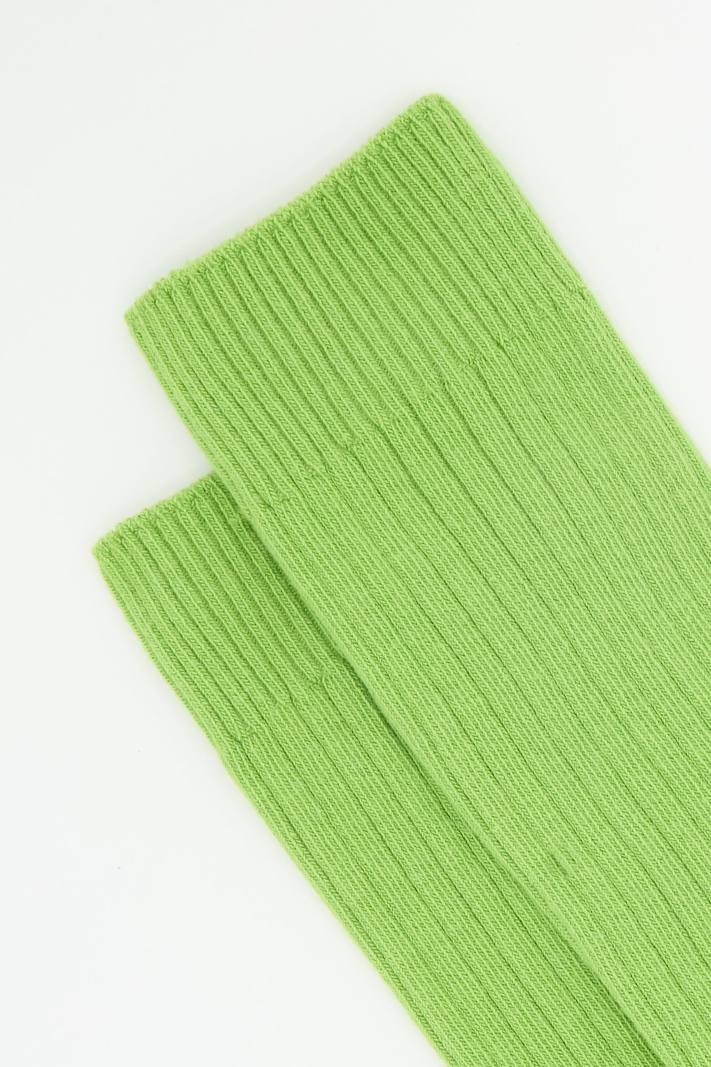 Close-up of Baserange Rib Overankle Socks in Spiral Green, crafted from organic cotton, displayed on a white background.