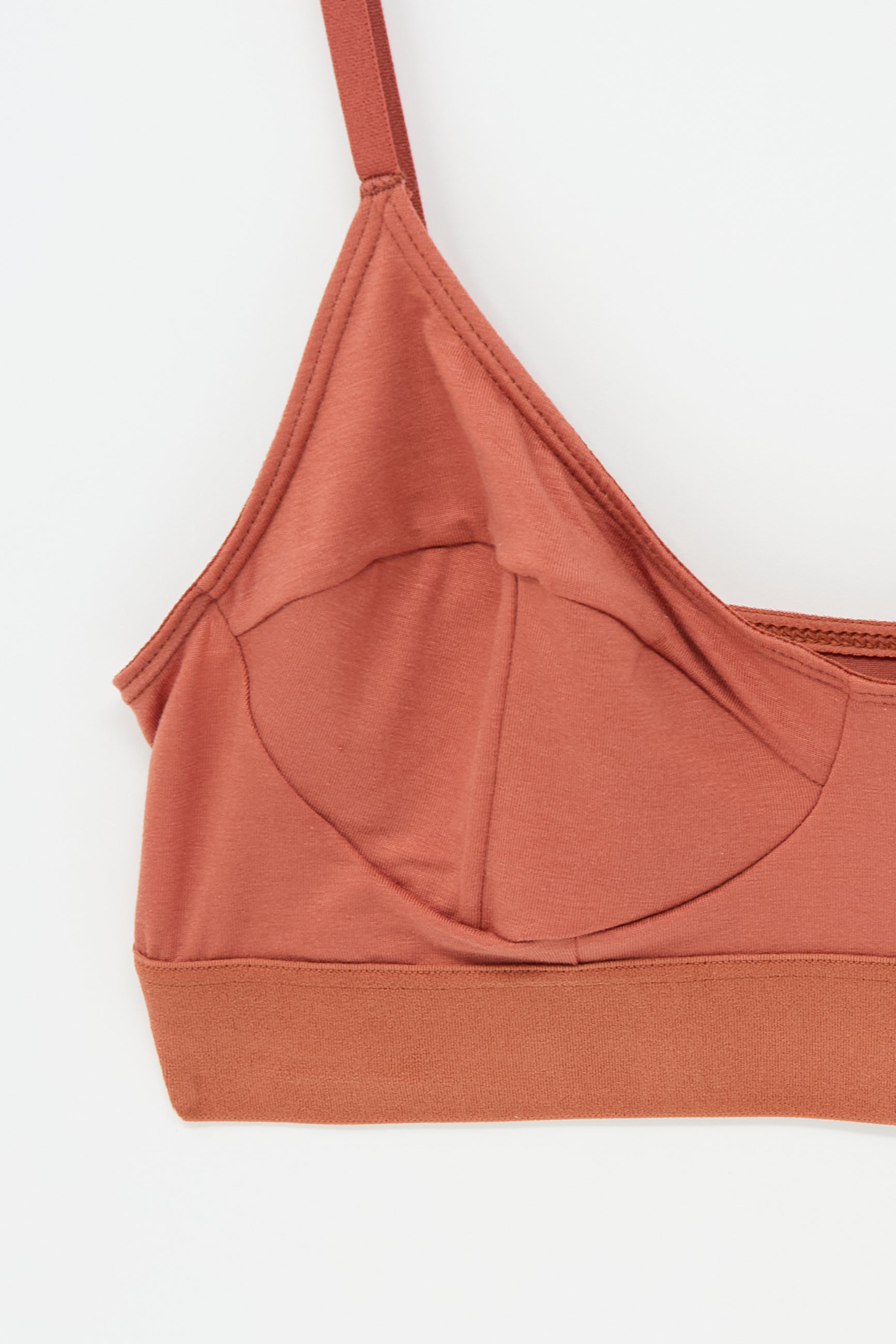 Close-up of the Soft Bra in Burned Red by Baserange, featuring thin, adjustable straps and a seamless, soft bamboo jersey fabric design.