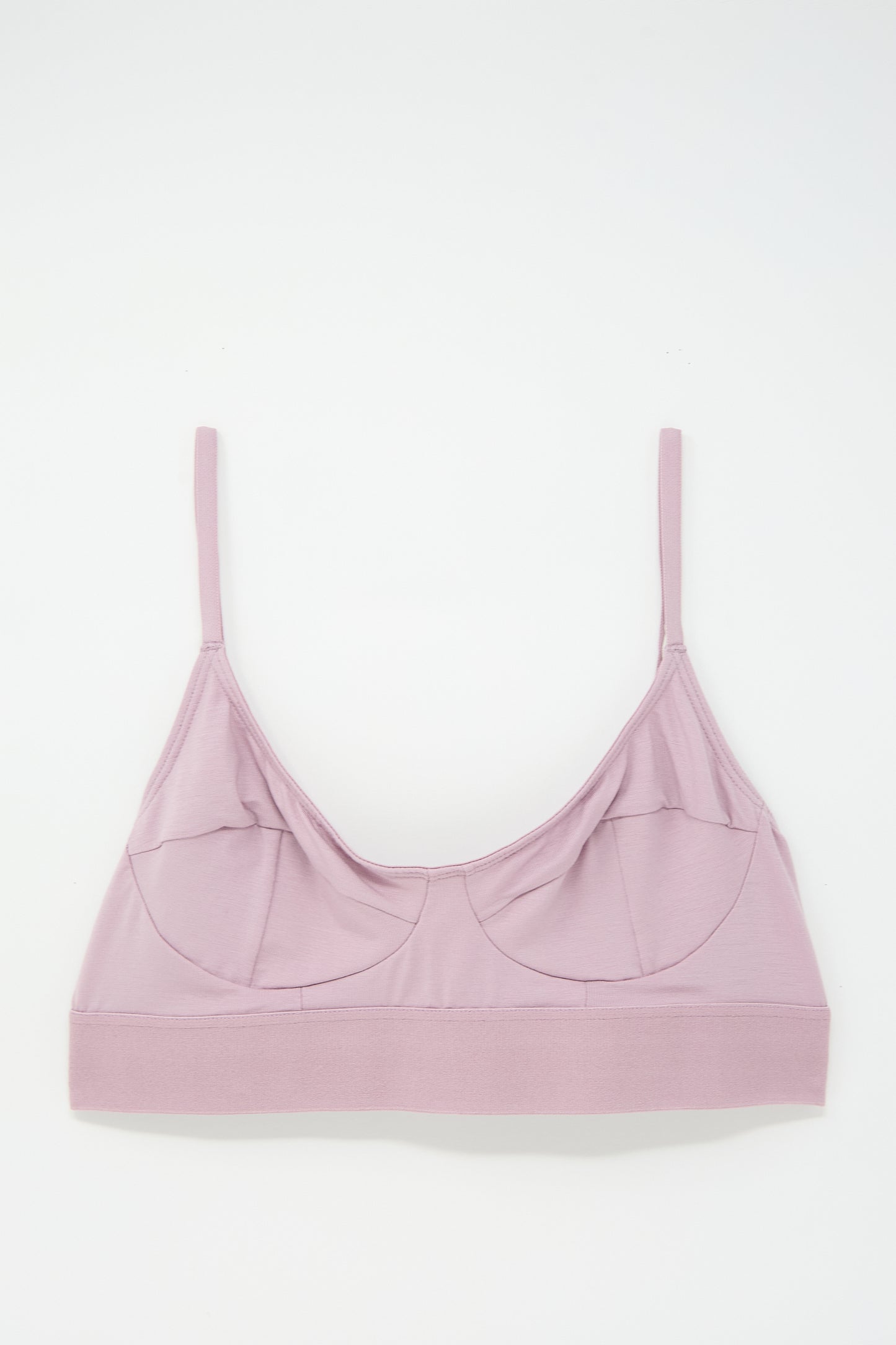 Light pink bralette made from soft bamboo jersey, featuring supportive seamed cups, thin adjustable straps, and a wide underband, laid flat on a white background.

Let’s revise this with the given product name and brand name:

Soft Bra in Still Purple by Baserange made from soft bamboo jersey, featuring supportive seamed cups, thin adjustable straps, and a wide underband, laid flat on a white background.