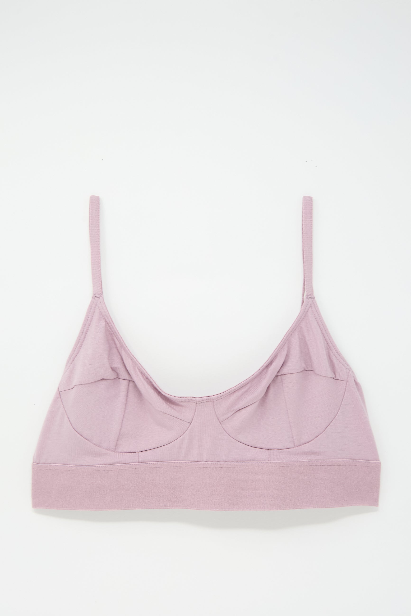 Light pink bralette made from soft bamboo jersey, featuring supportive seamed cups, thin adjustable straps, and a wide underband, laid flat on a white background.

Let’s revise this with the given product name and brand name:

Soft Bra in Still Purple by Baserange made from soft bamboo jersey, featuring supportive seamed cups, thin adjustable straps, and a wide underband, laid flat on a white background.