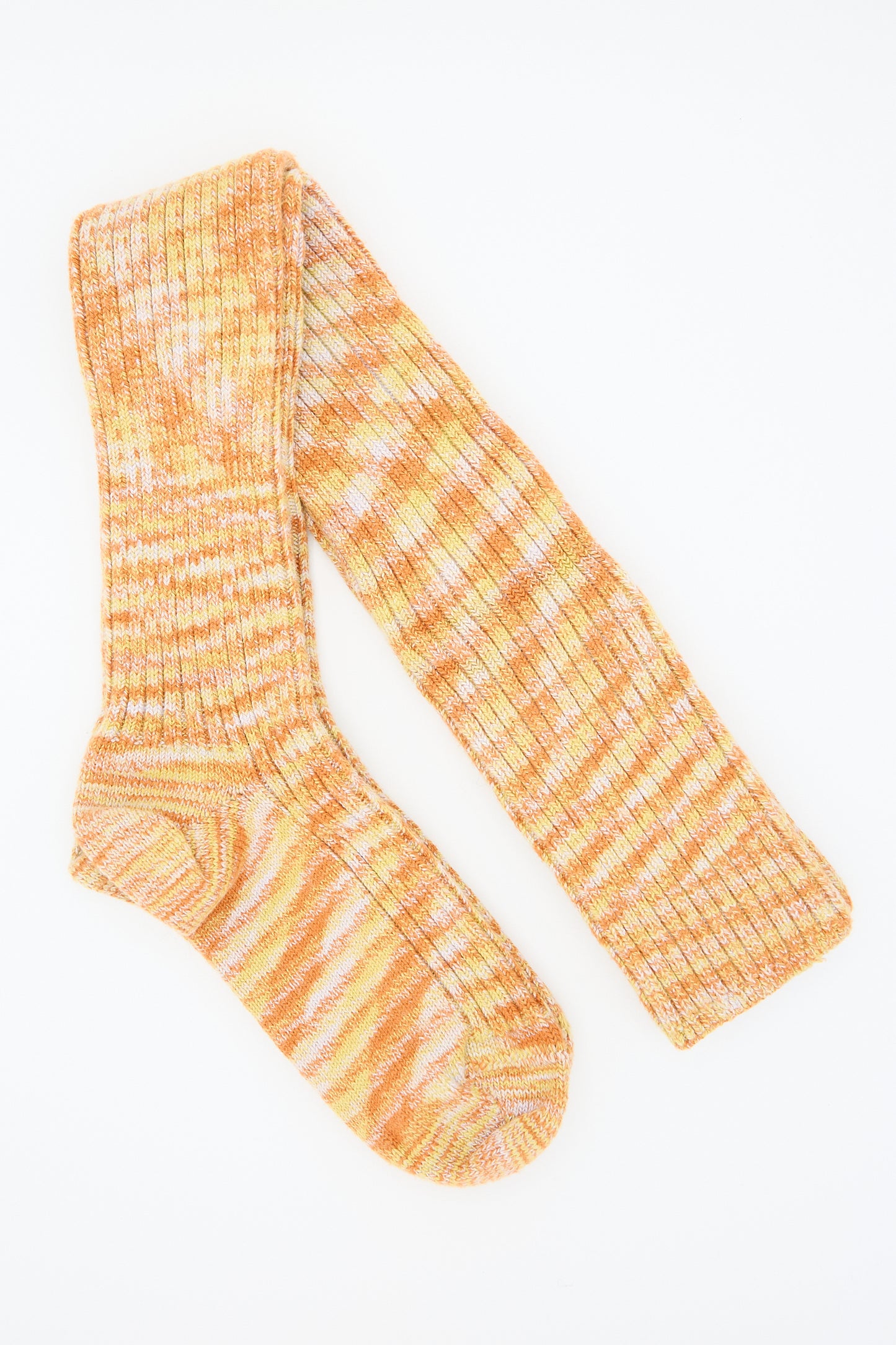 A pair of Baserange Twisted Overknee Socks in Orange Multicolor, featuring a rib knit made from organic cotton and an orange and white marbled pattern, arranged flat on a white background.