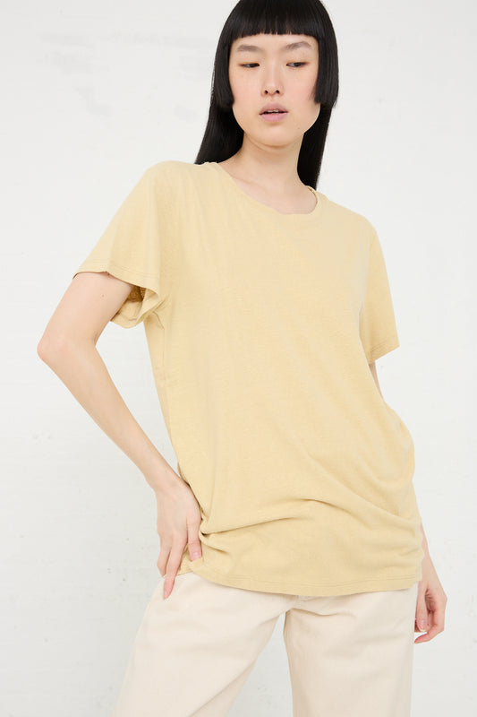 Woman in a casual beige, sustainably produced Wild Silk Jersey Tee in Oak Yellow and pants by Baserange posing against a white background.