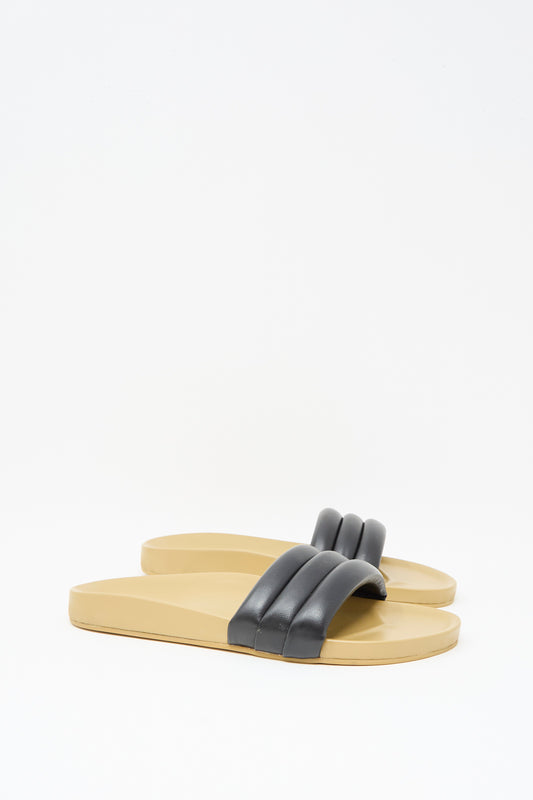 A pair of Classic Sandalia in Black by Beatrice Valenzuela, featuring thick, padded black lambskin uppers, is displayed against a plain white background.