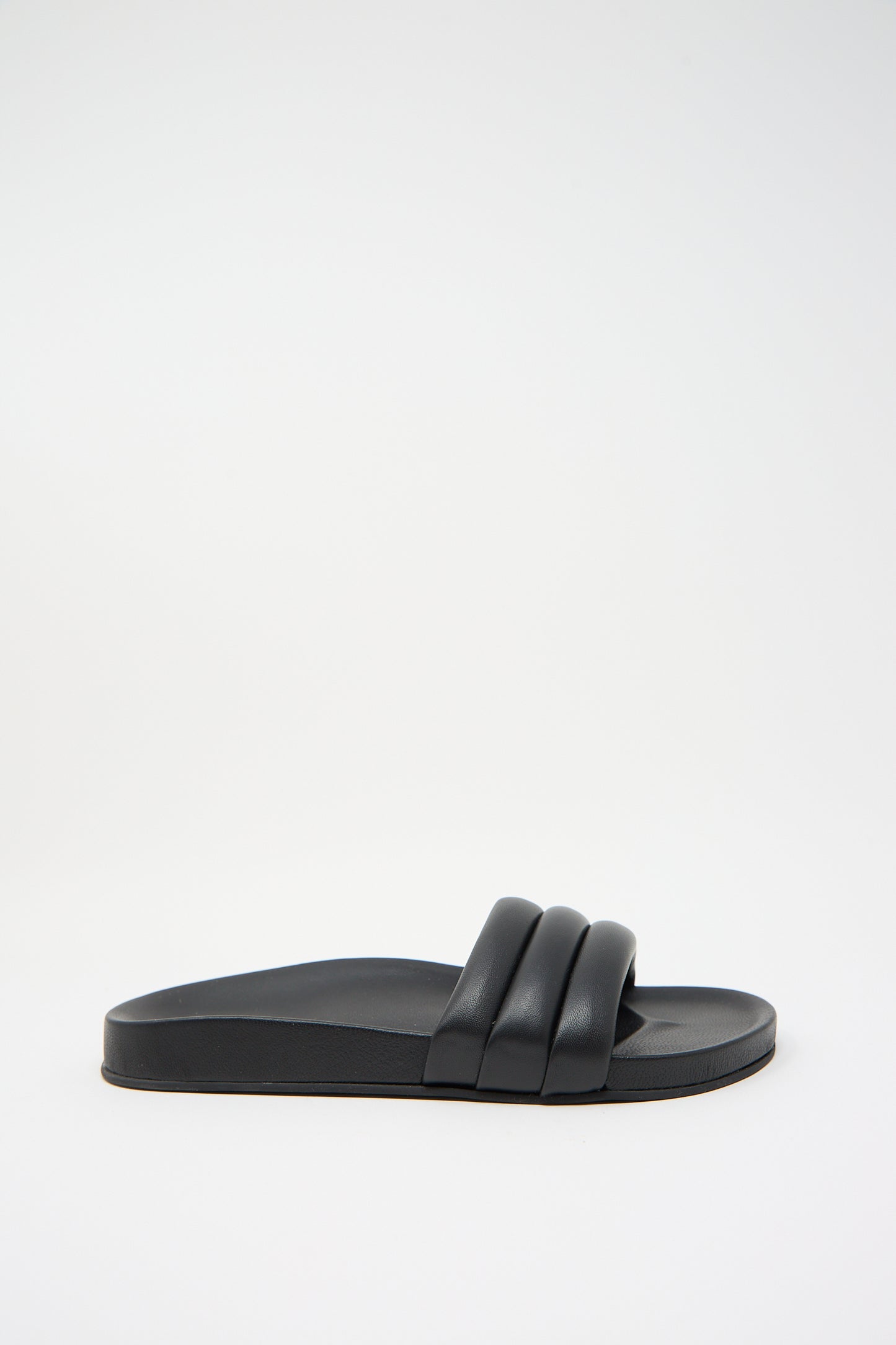 A single Monocolor Sandalia in Black by Beatrice Valenzuela with a thick, double-strap design and a flat sole, featuring luxurious leather uppers, positioned against a plain white background.