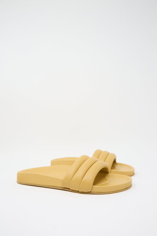 A pair of Beatrice Valenzuela Monocolor Sandalia in Wheat with two straps on each foot, featuring lambskin uppers, posed on a white background.
