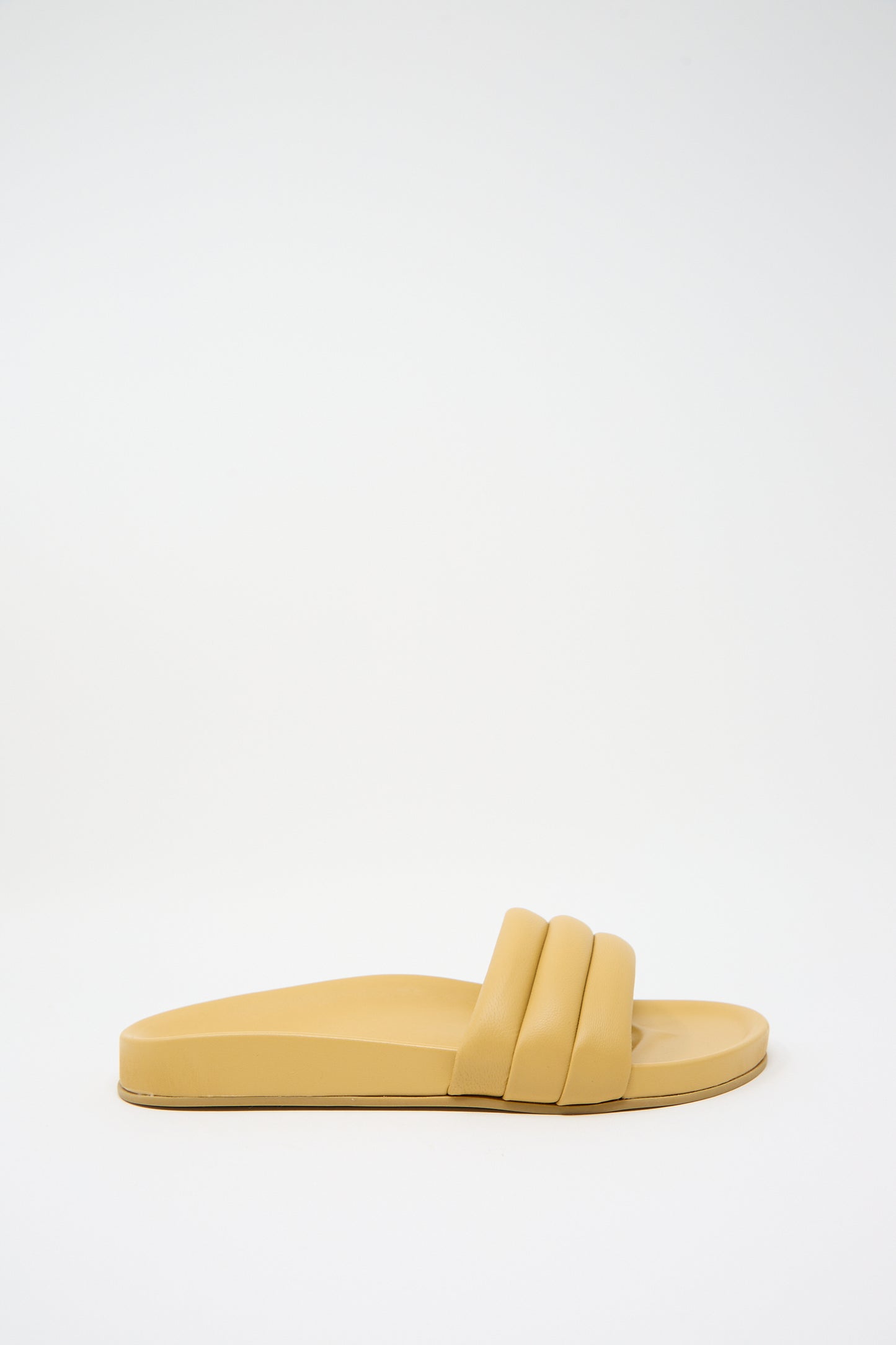 Yellow Monocolor Sandalia in Wheat by Beatrice Valenzuela with two wide straps and a flat sole, featuring handcrafted slides made from 100% leather, set against a plain white background.