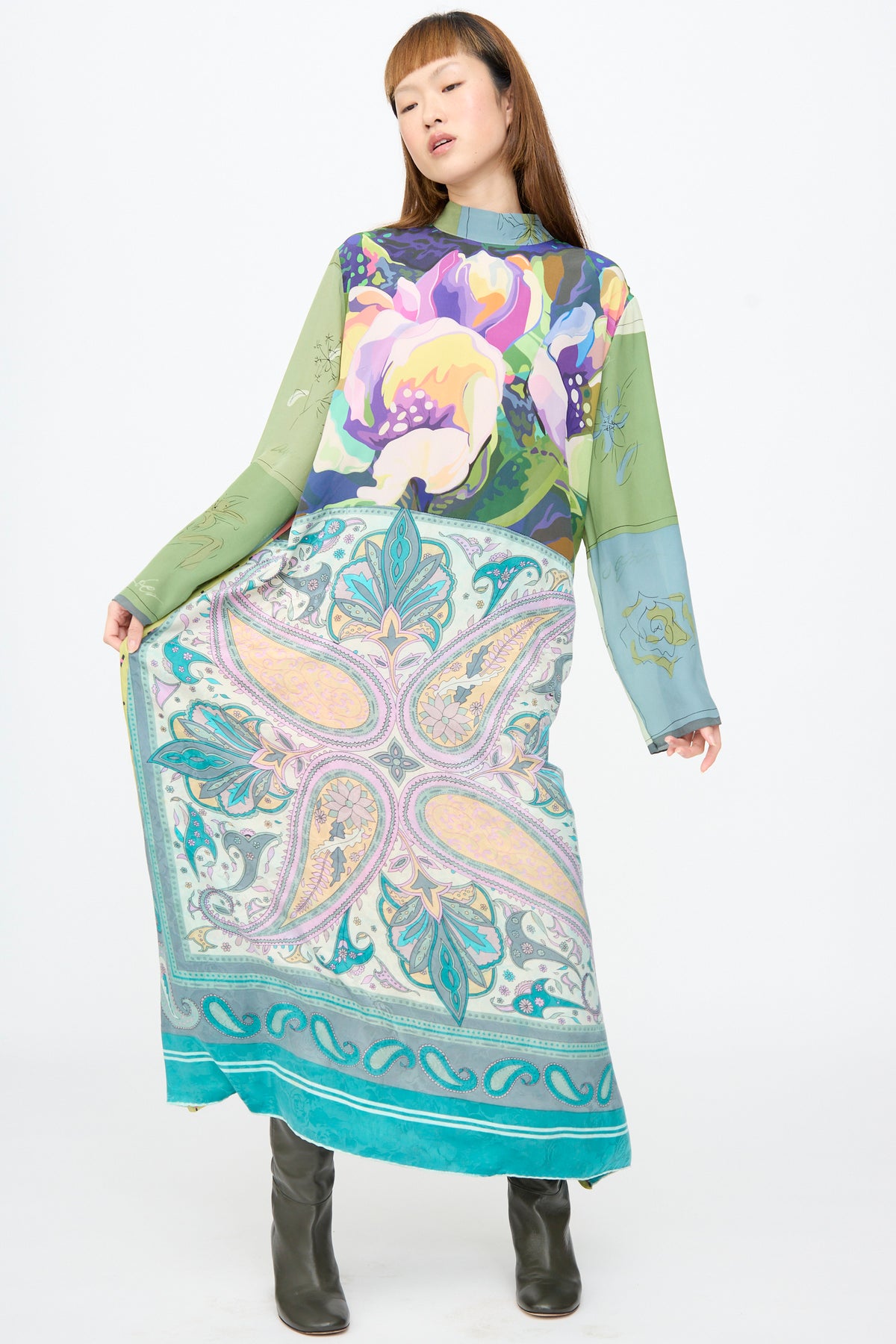 A person wearing a Bettina Bakdal Classic Mandarin Collar Dress in Hedwig Arheim, an up-cycled long-sleeved midi dress with a floral print bodice and a large paisley pattern skirt.