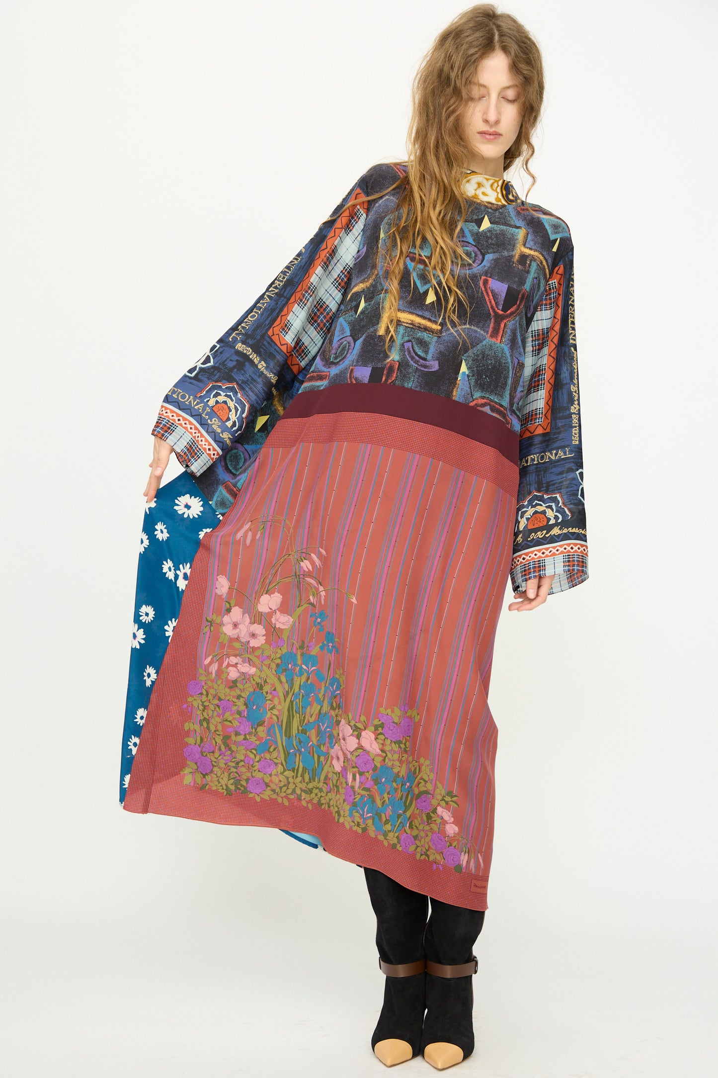 A woman wears the Bettina Bakdal Classic Mandarin Collar Vintage Scarves Dress in Myriam Manuckiam, styled over black pants and shoes, standing against a plain white background.