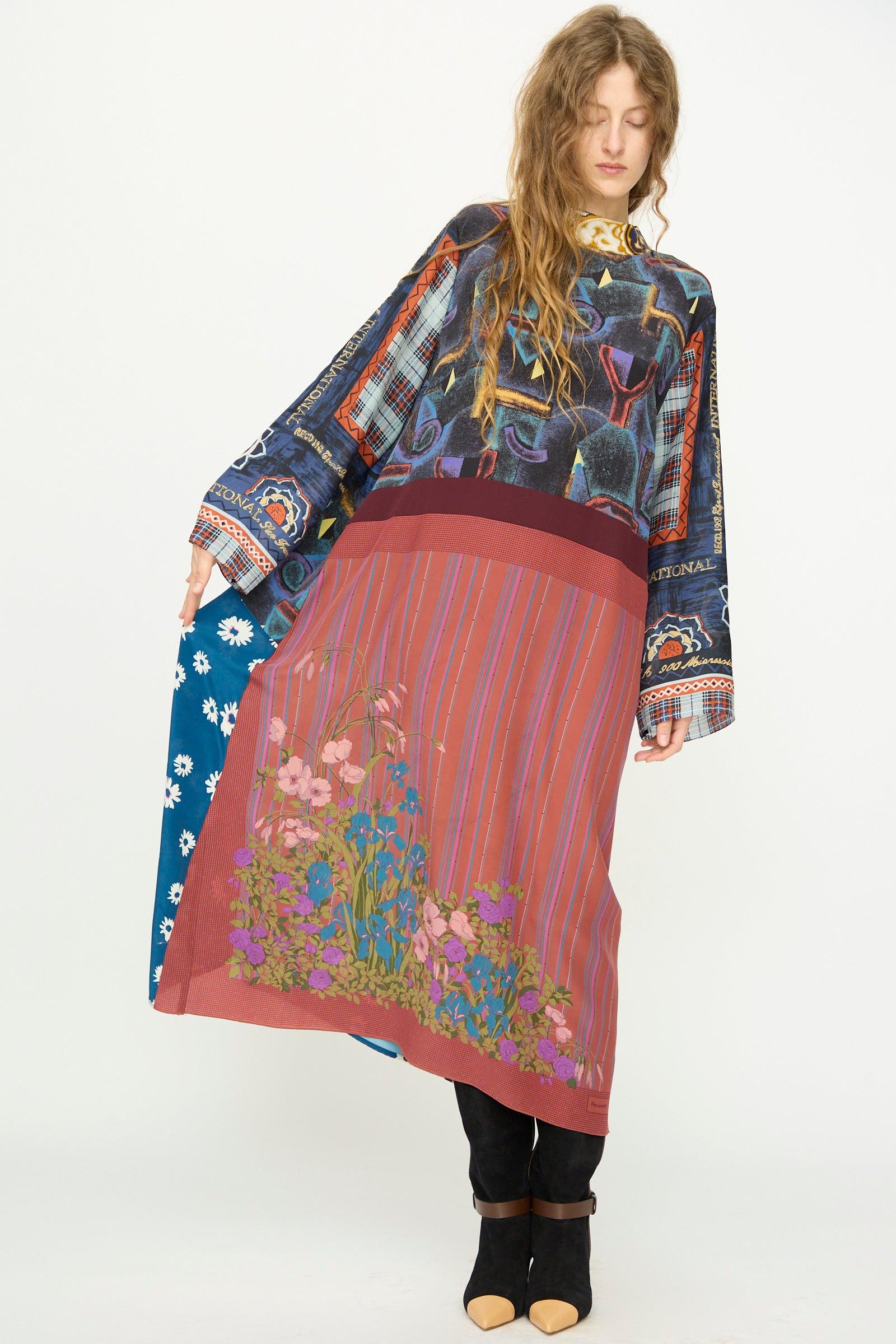 A woman wears the Bettina Bakdal Classic Mandarin Collar Vintage Scarves Dress in Myriam Manuckiam, styled over black pants and shoes, standing against a plain white background.