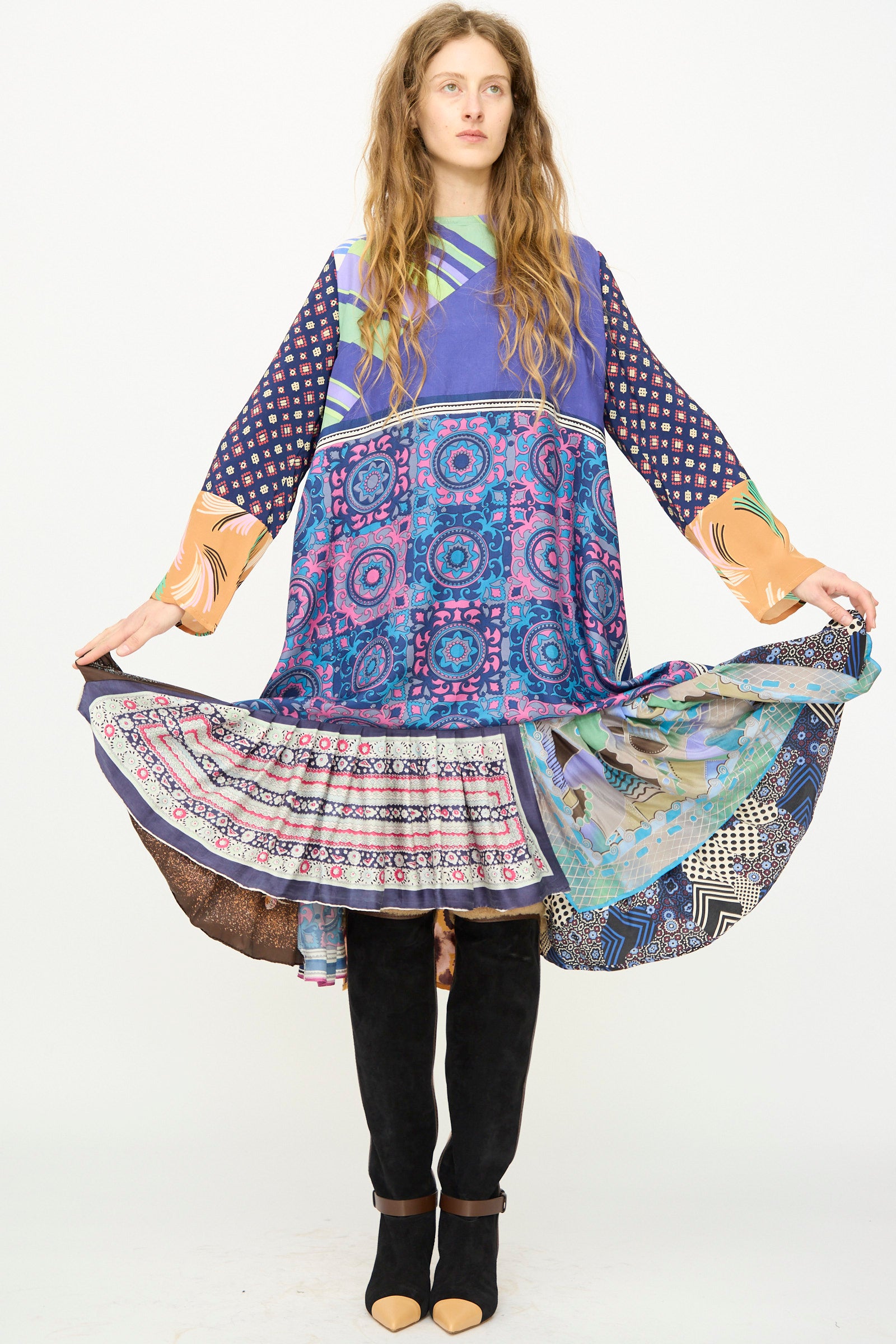 A woman in the Bettina Bakdal Hannah Silk Dress in Ricarda Meltzer, paired with black leggings and shoes, stands against a plain white background.