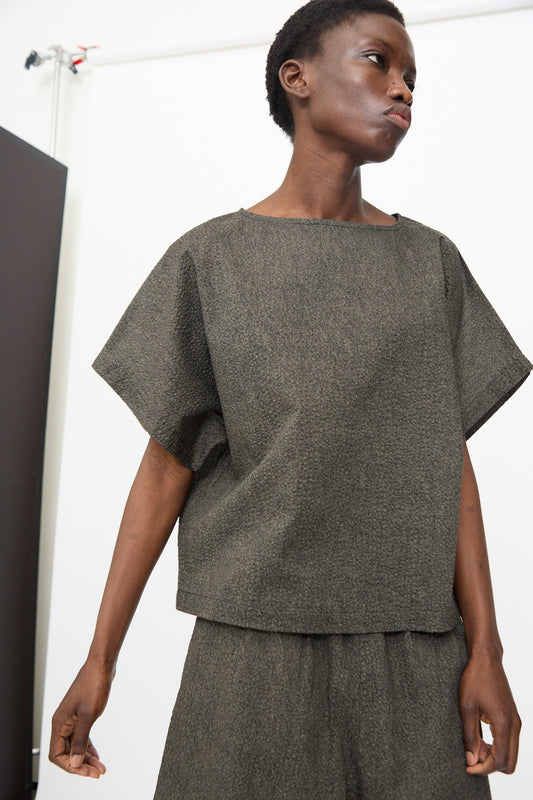 A person wears the Black Crane Box Top with Micro Wave Texture in Steel and matching relaxed shorts, standing against a plain white background.