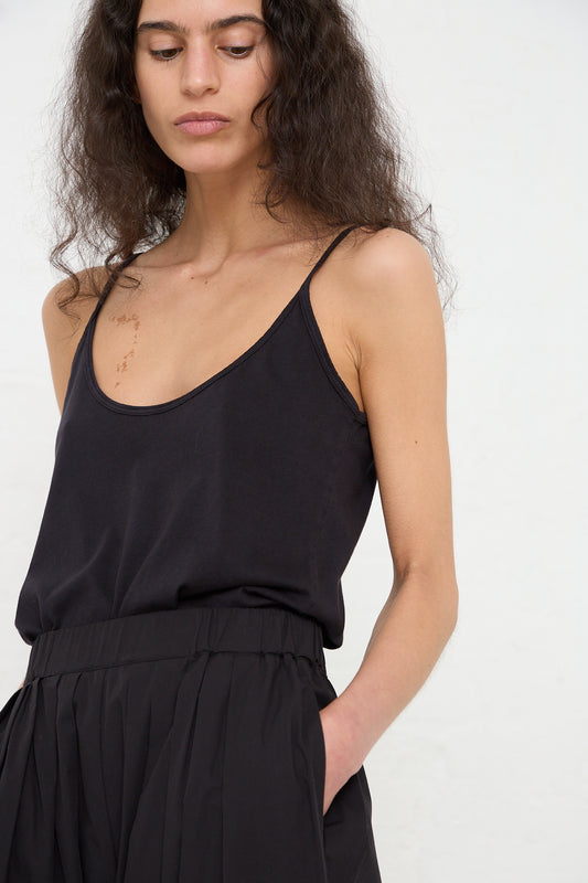 Woman in a Black Crane black organic cotton jersey camisole top and skirt looking downward.