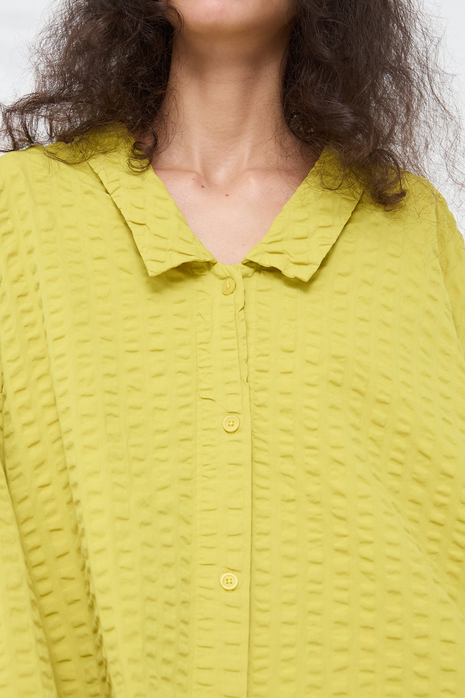 Woman wearing a yellow Cotton Seersucker Chelsea Collar Shirt in Turmeric from Black Crane.