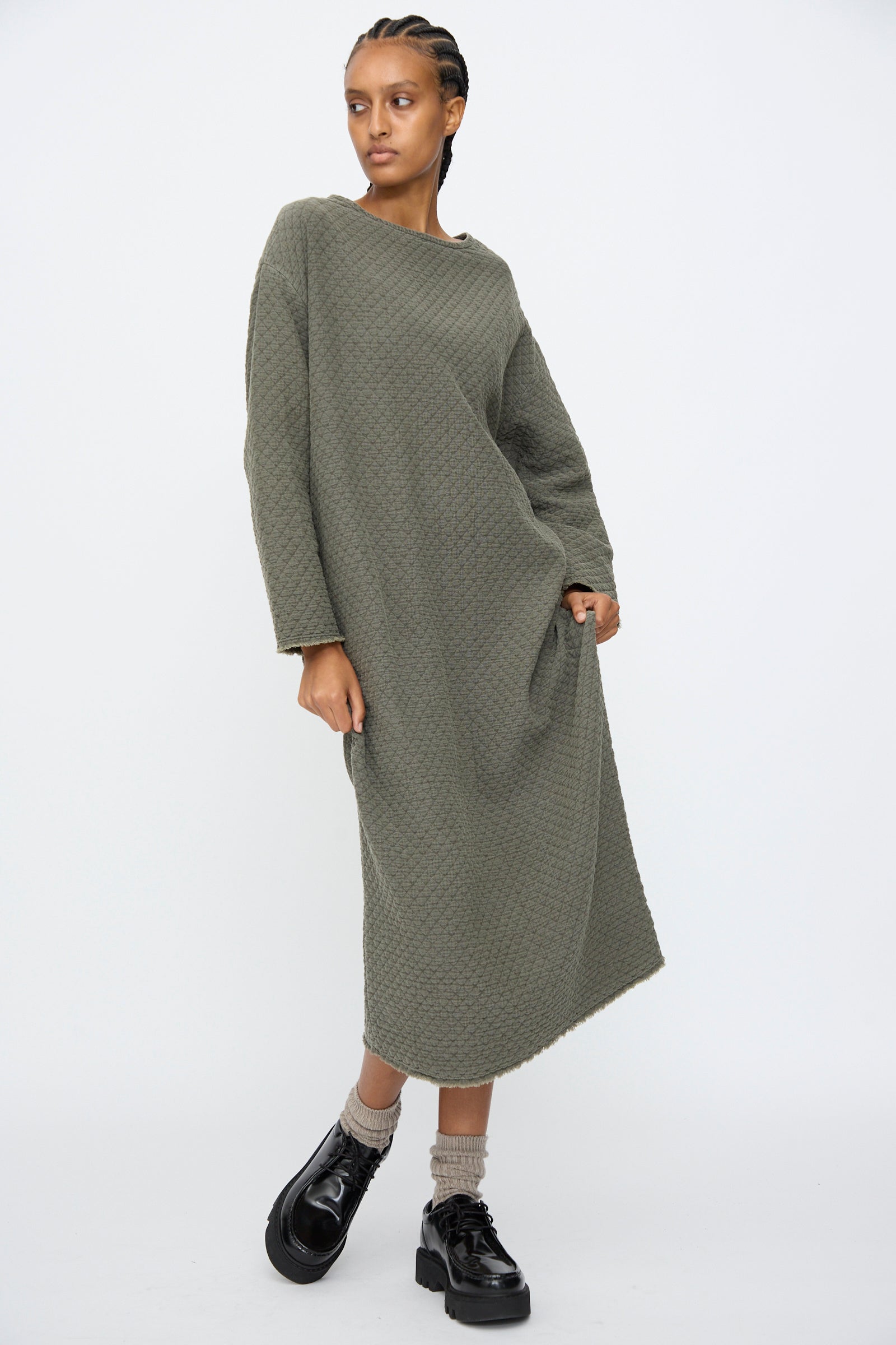 A person wears the Black Crane Diamond Quilted Dress in Slate with black platform shoes, standing against a plain white background.