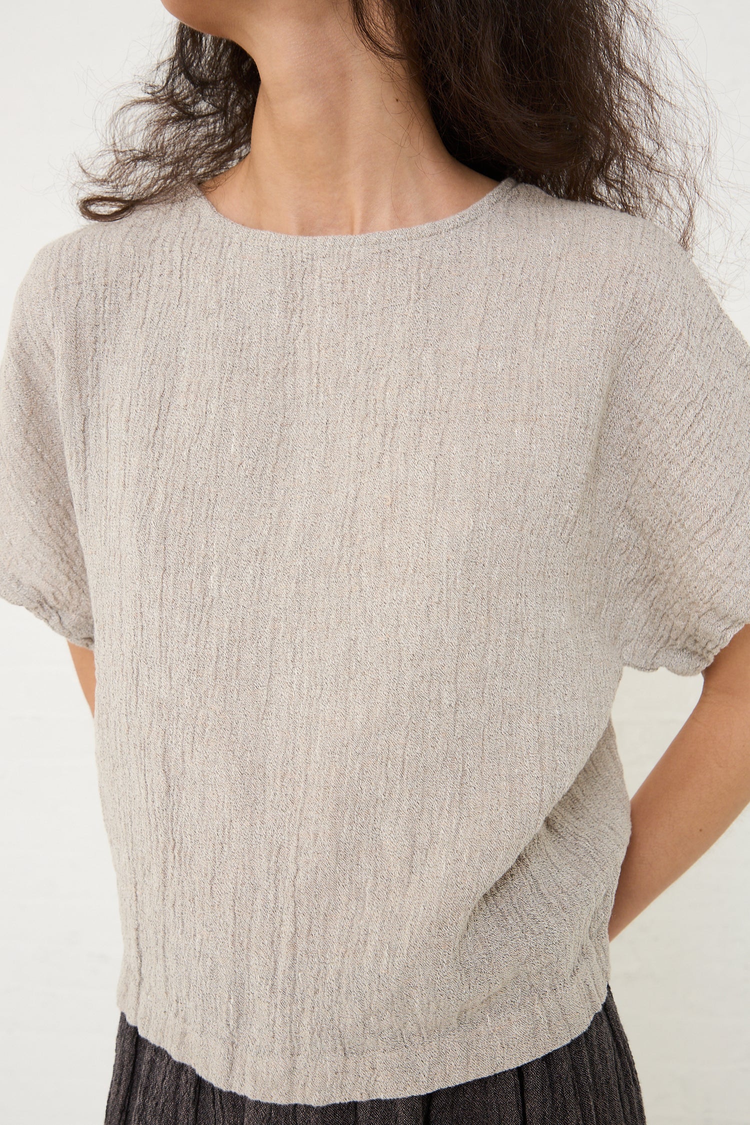 Woman wearing a textured beige Black Crane Linen Basic Crew Top in Ash, made in Los Angeles.