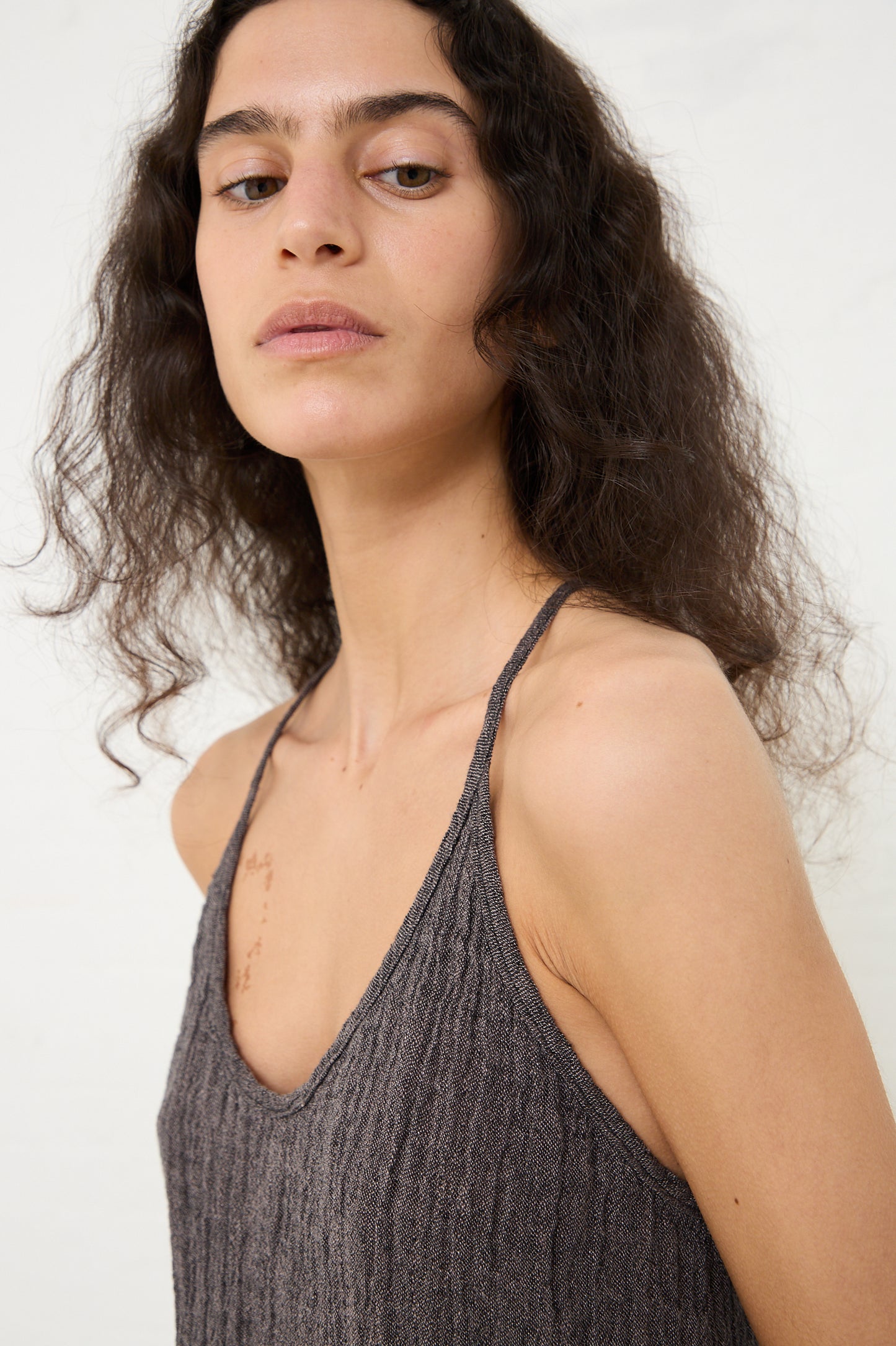 Woman posing in a Black Crane Linen Textured Camisole in Grey Navy top against a white background.