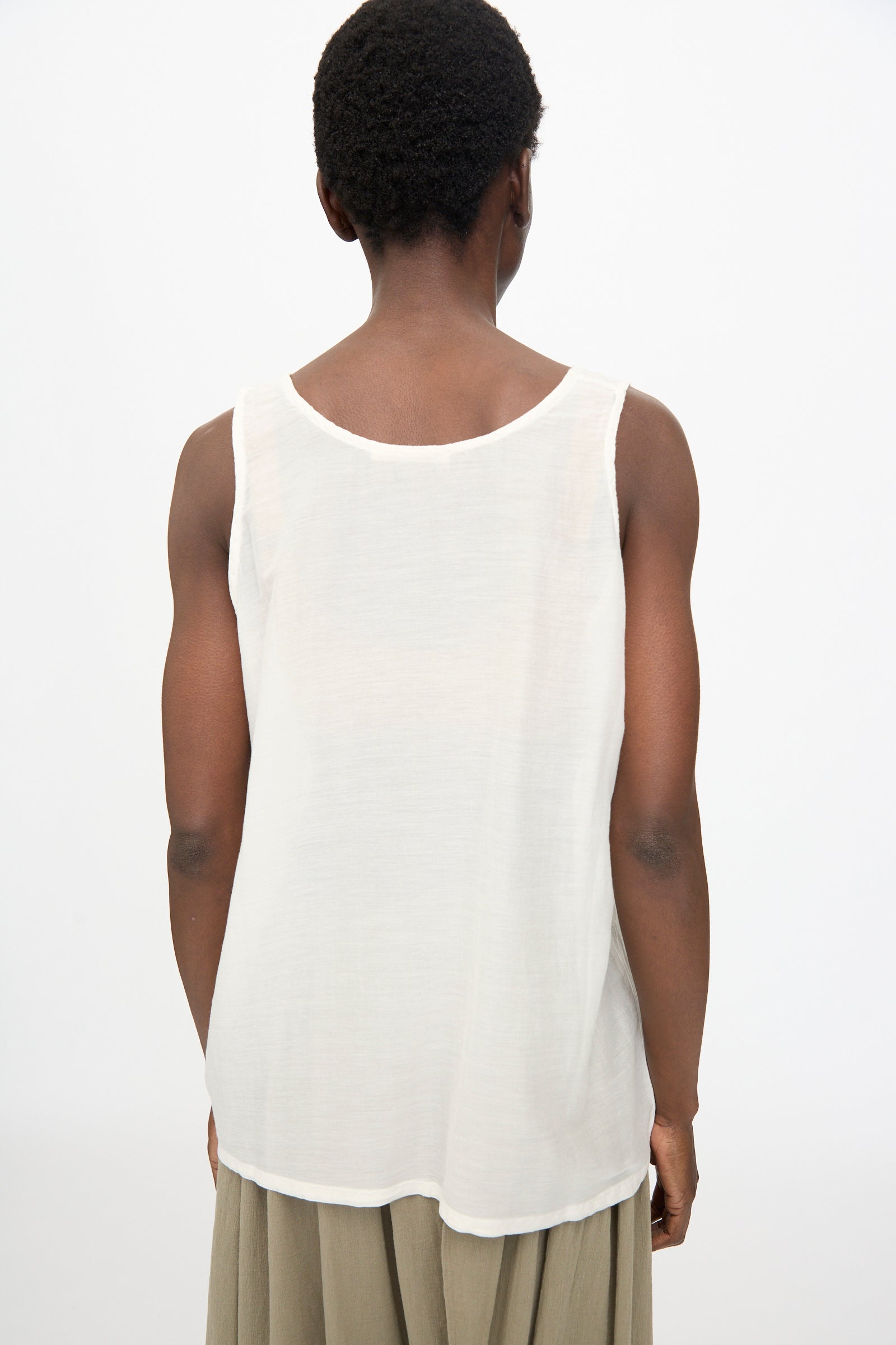 A person is shown from the back wearing the Black Crane Loose Tank Top in White against a plain white background.