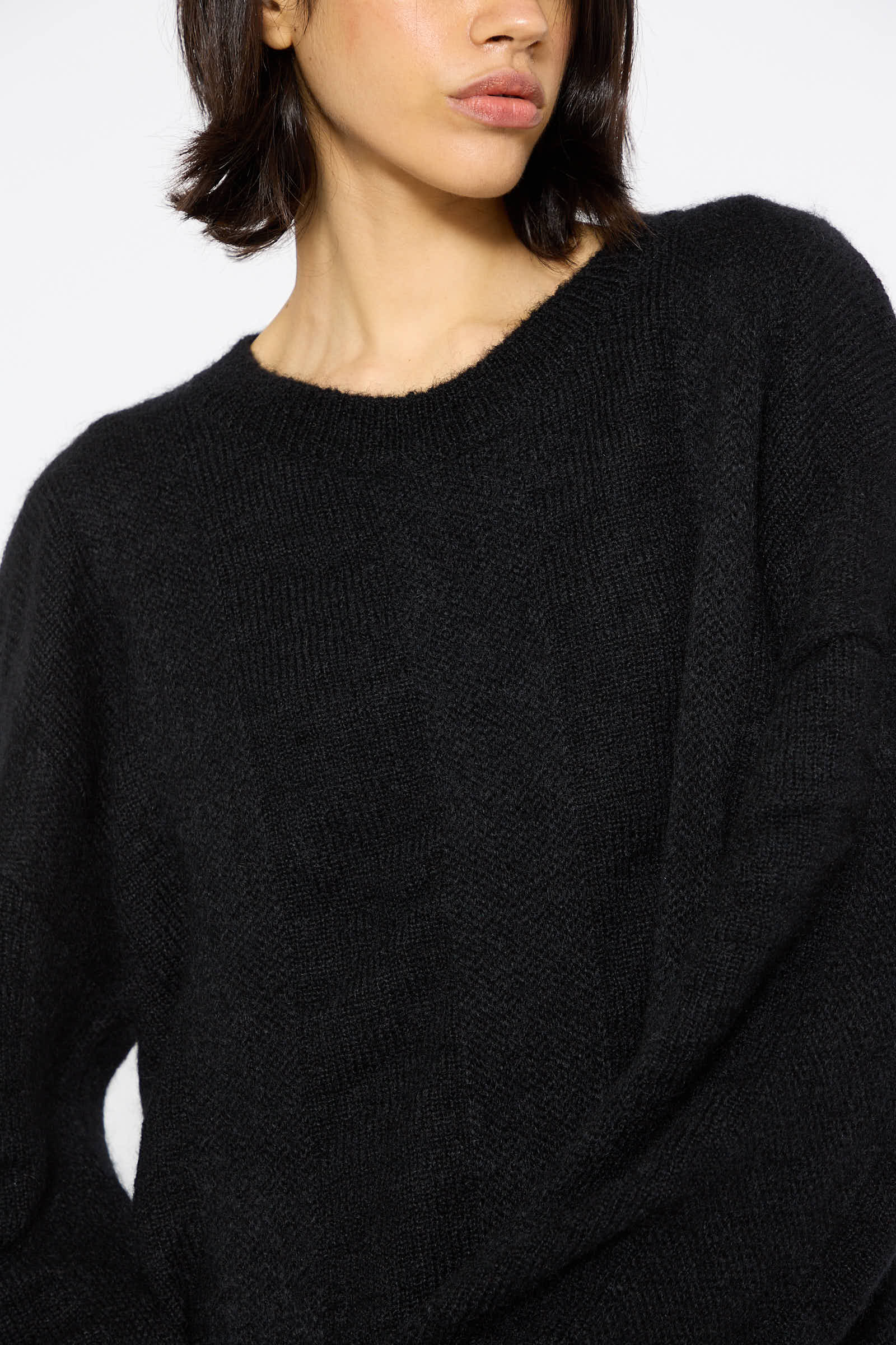 Person wearing a Mohair and Wool Waterfall Knit Dress in Black by Black Crane, facing slightly to the side against a plain white background.