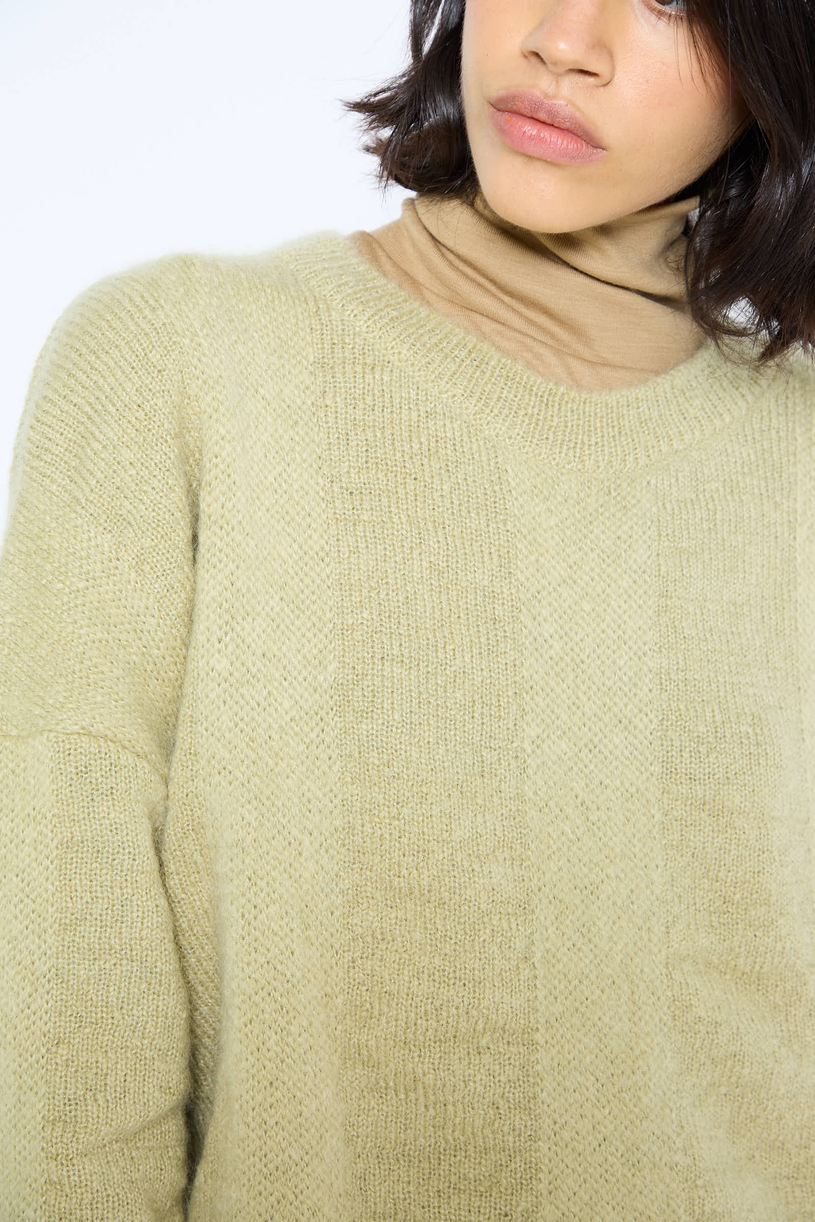 Close-up of a person wearing the Mohair and Wool Waterfall Knit Dress in Lime by Black Crane, partially cropped at the shoulders and lips, showcasing its delicate texture reminiscent of a Japanese mohair blend.