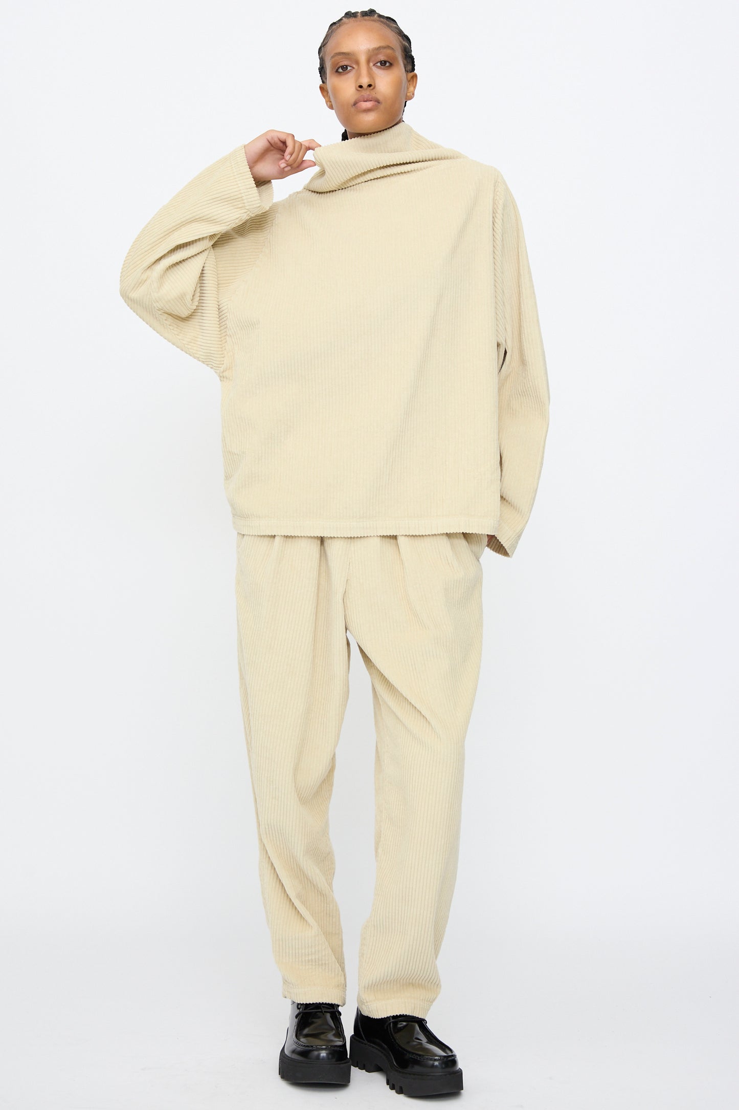 A person wears the Black Crane Tube Top in Ivory with matching pants and black platform shoes, standing against a plain white background.