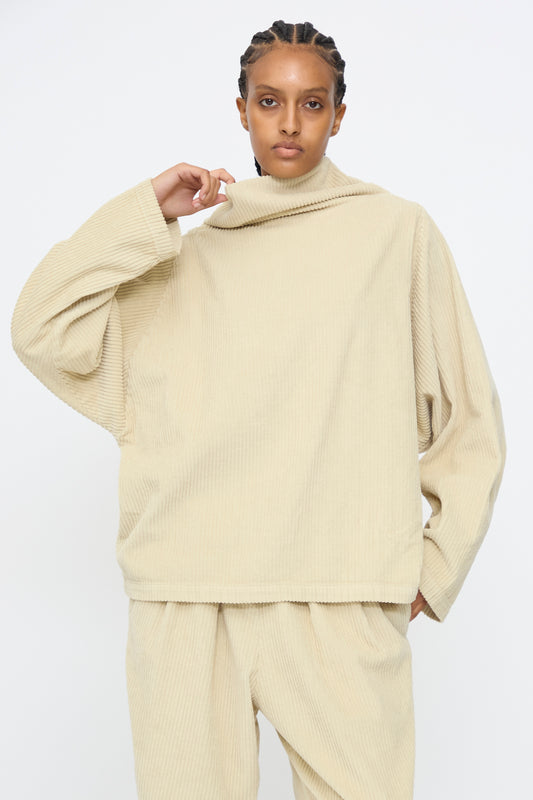 A person wearing the Black Crane Tube Top in Ivory, featuring a loose, boxy cotton corduroy fit, paired with matching pants and standing against a plain white background.