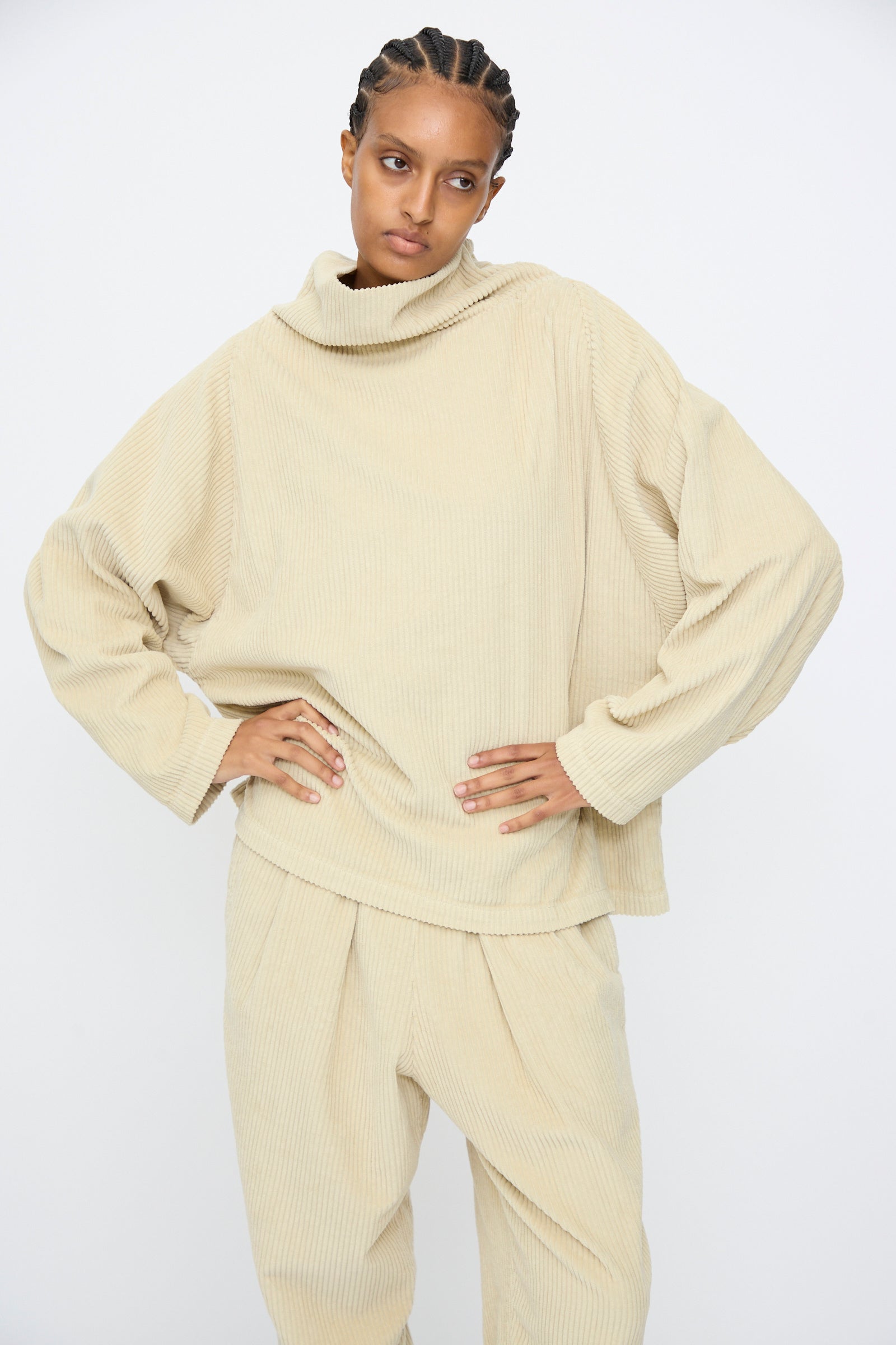 Model wearing the Black Crane Tube Top in Ivory with hands on hips, standing against a plain white background.