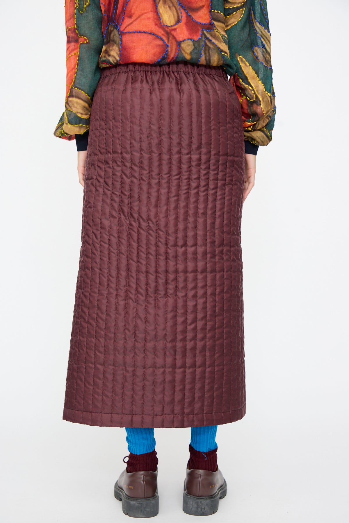 Back view of a burgundy No. 08 Monpe Skirt in quilted nylon with an adjustable snap waistband.
