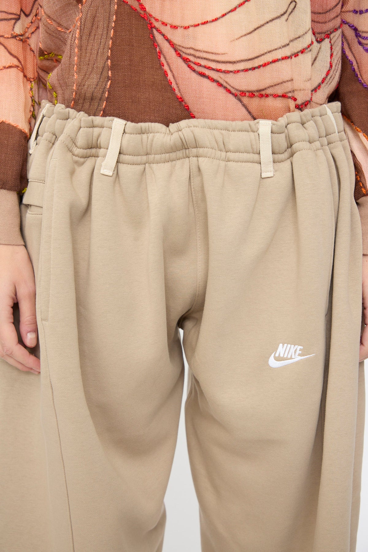 Bless No. 61 Overjoggingjeans in Beige and Sand are relaxed fit sweatpants with an elastic waistband and a white Nike logo on the hip.