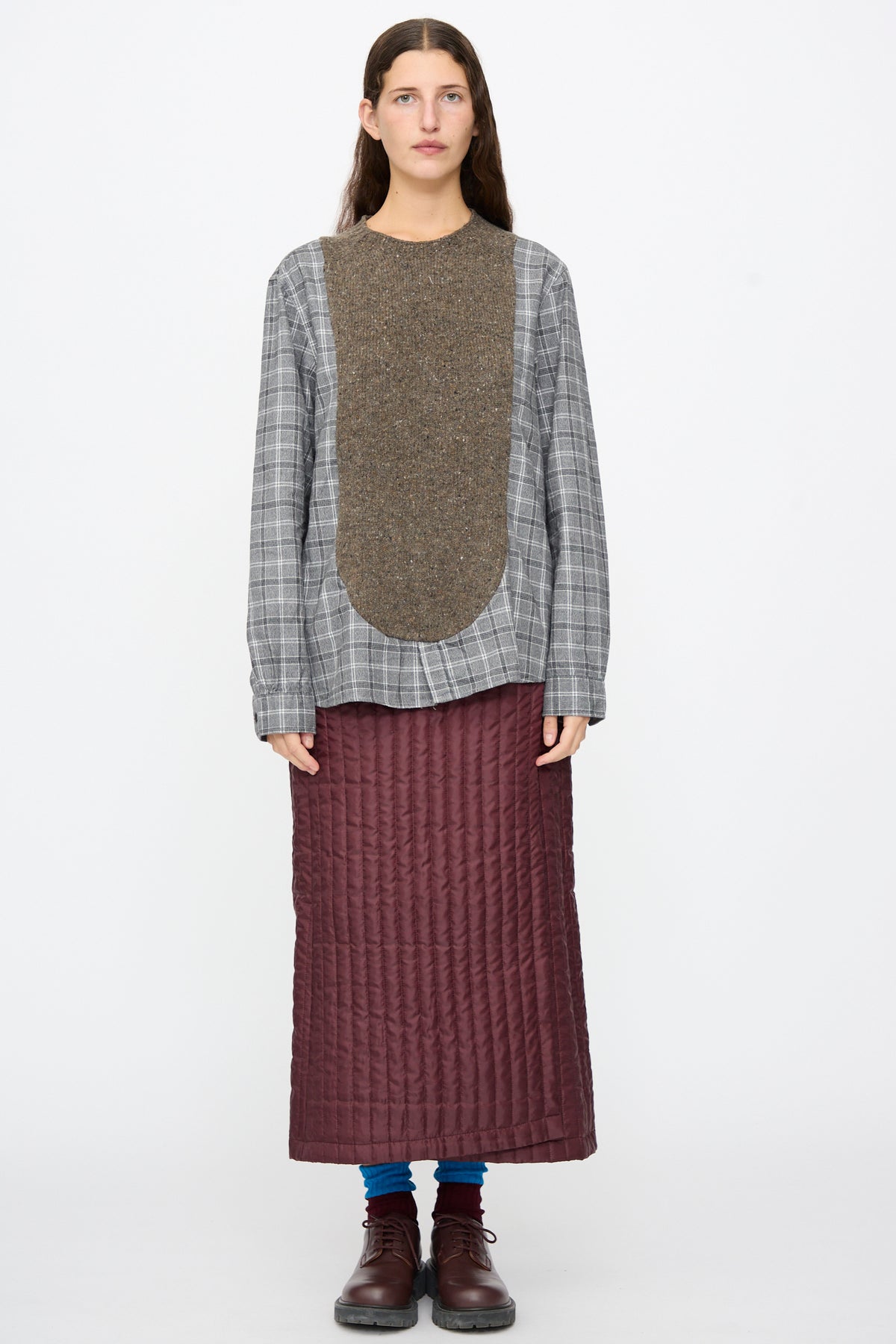 A person wearing the Bless No. 68 Frontinsertpullover in Unique I, featuring a brown knit panel, paired with a long, quilted burgundy skirt and dark brown shoes.