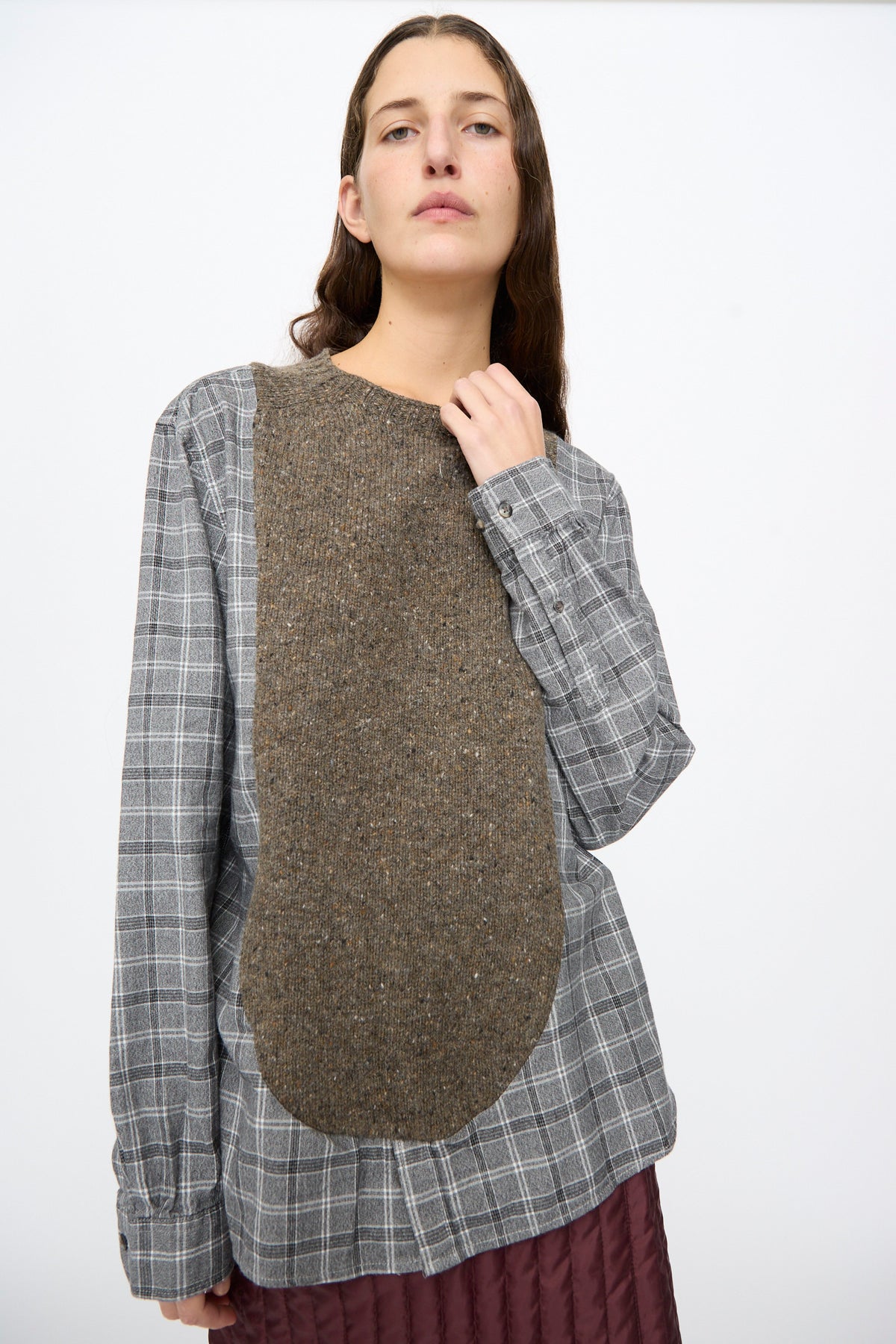 A model wears the Bless No. 68 Frontinsertpullover in Unique I, a relaxed-fit grey plaid flannel pullover featuring a solid brown wool-blend panel inserted vertically across the front.