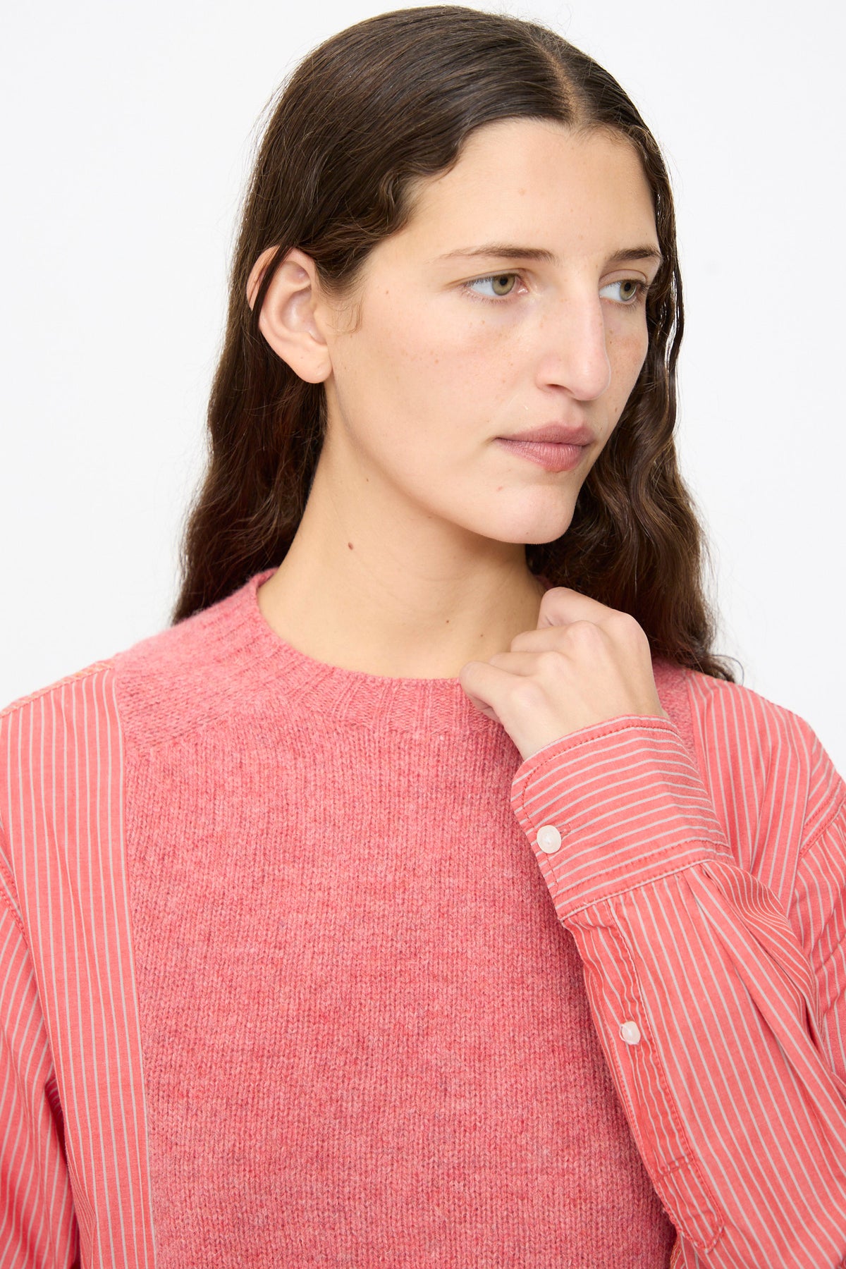 A model wears a Bless No. 68 Frontinsertpullover in Unique II, featuring a pink shetland wool knit front panel and red-and-white pinstriped poplin pullover sleeves.
