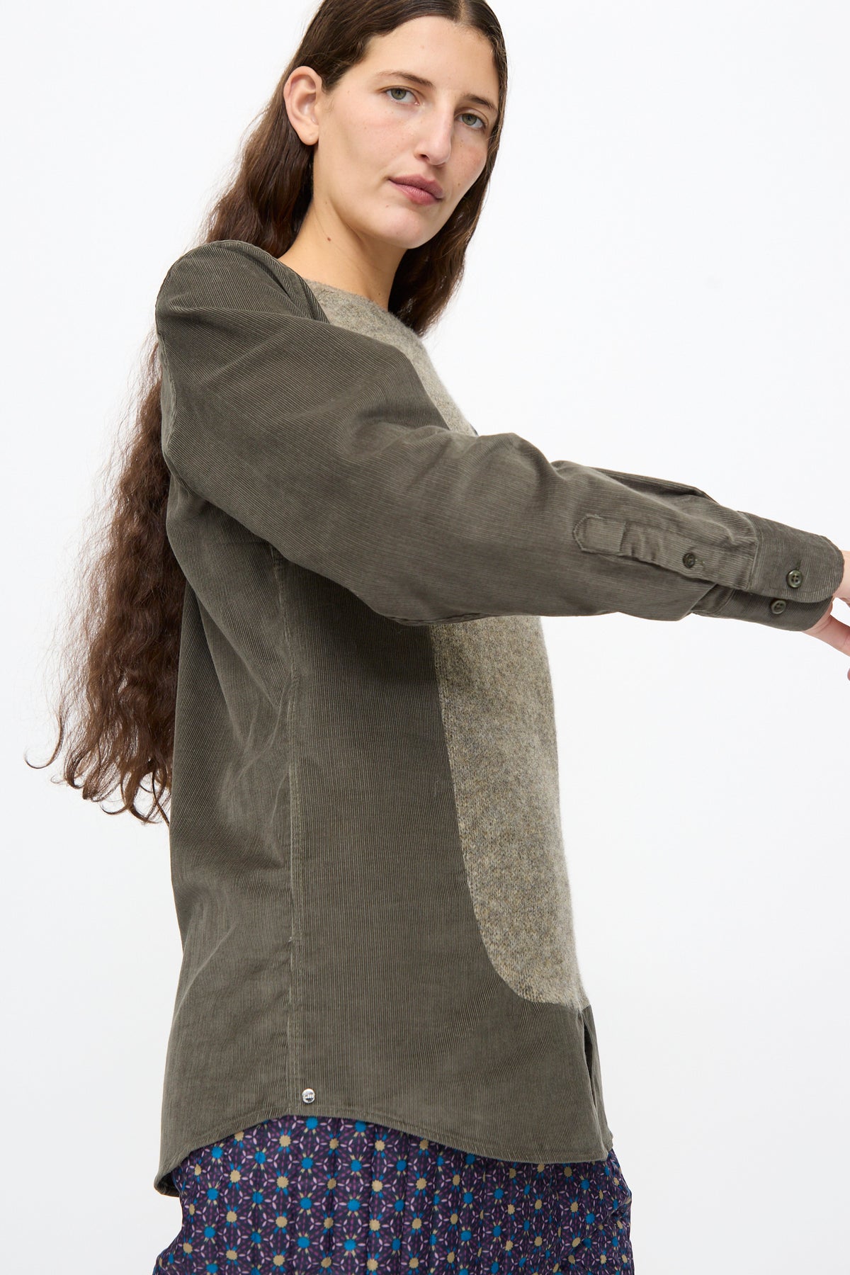 Bless No. 68 Frontinsertpullover in Unique III: a relaxed-fit corduroy pullover with olive green sleeves and back, a heathered beige front panel, and a patterned blue-and-gold hem.