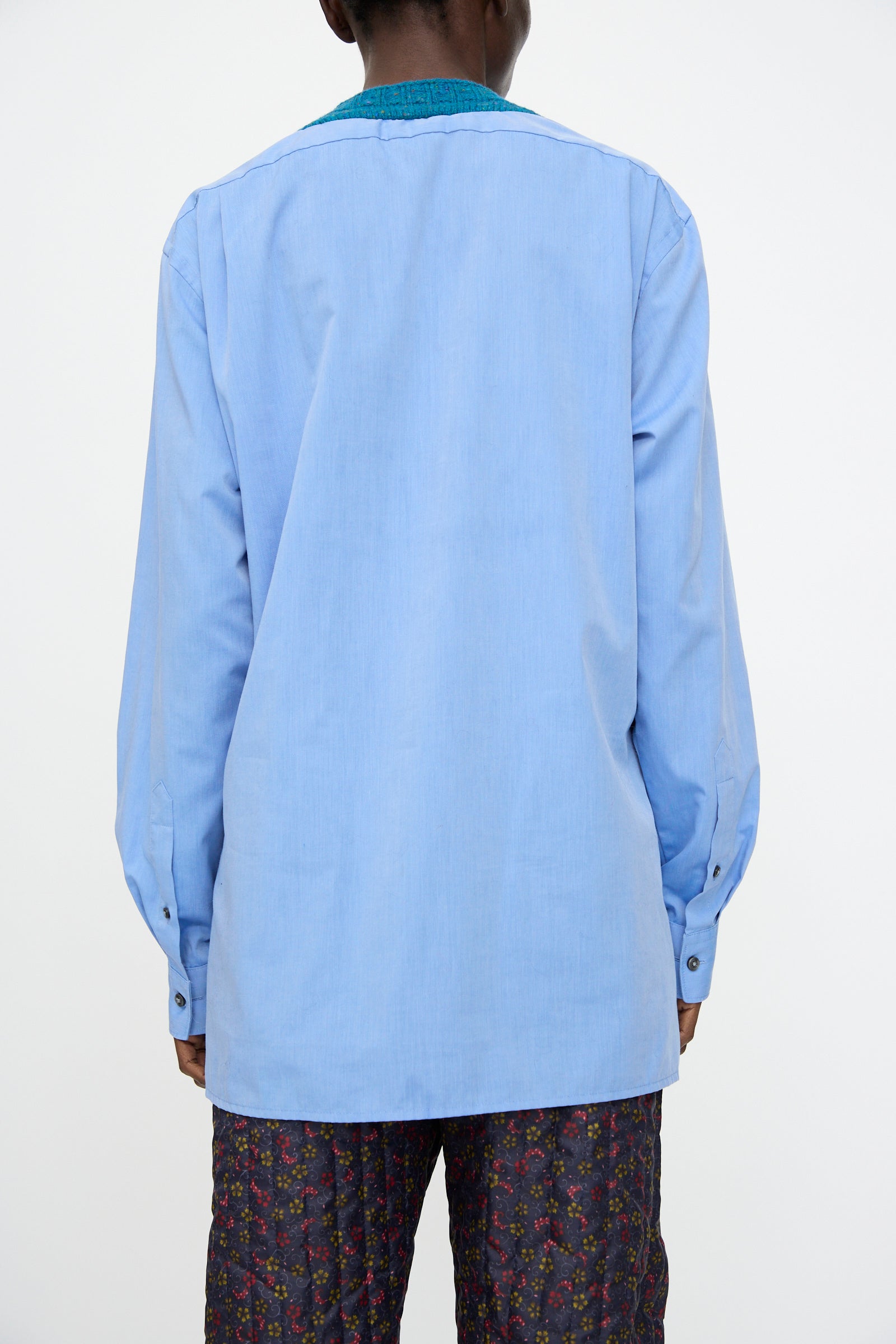 A person is shown from the back against a plain background wearing the Bless No. 68 Frontinsertpullover in Unique III and patterned pants.