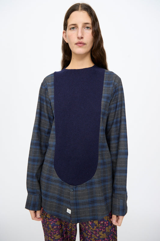 Bless No. 68 Frontinsertpullover in Unique IV: a long-sleeved shetland wool pullover featuring a large, solid navy blue knit panel centered over a blue and grey flannel shirt.