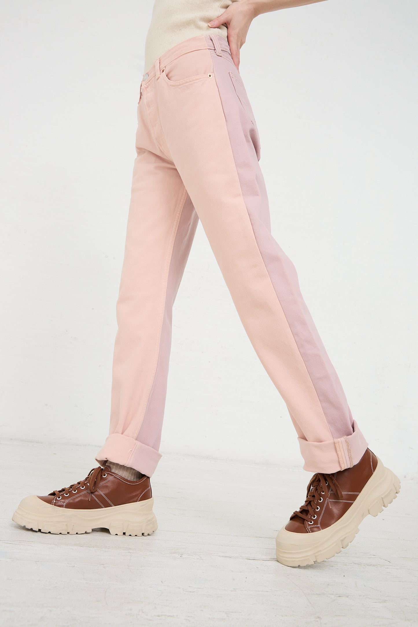 A person walking wearing Bless No. 73 Jeanspleatfront in Pink/Purple and brown shoes with thick soles.