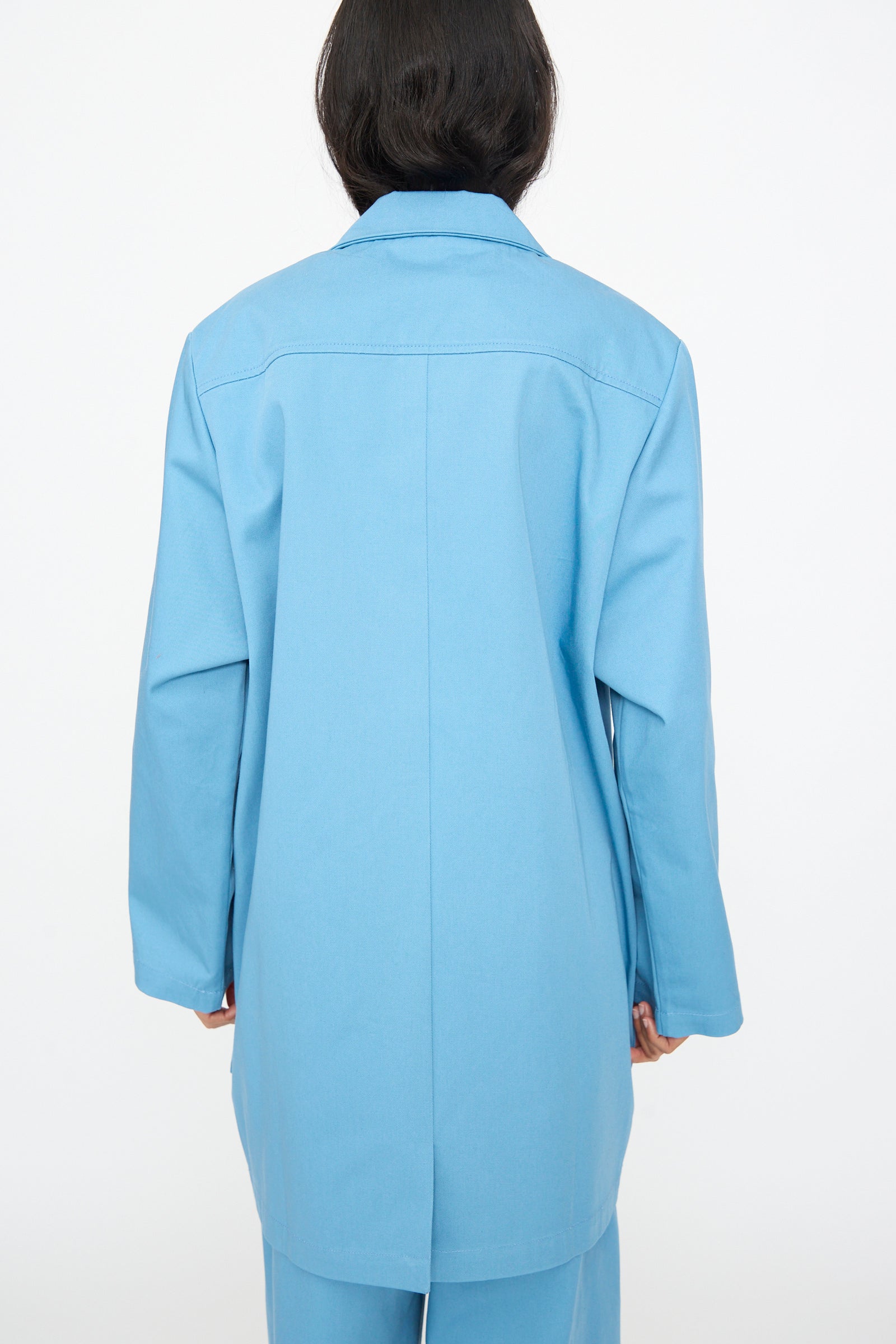 Model wears the Bless No. 81 Summer Workcoat Short in Skyblue, shown from the back with matching pants against a plain white background.