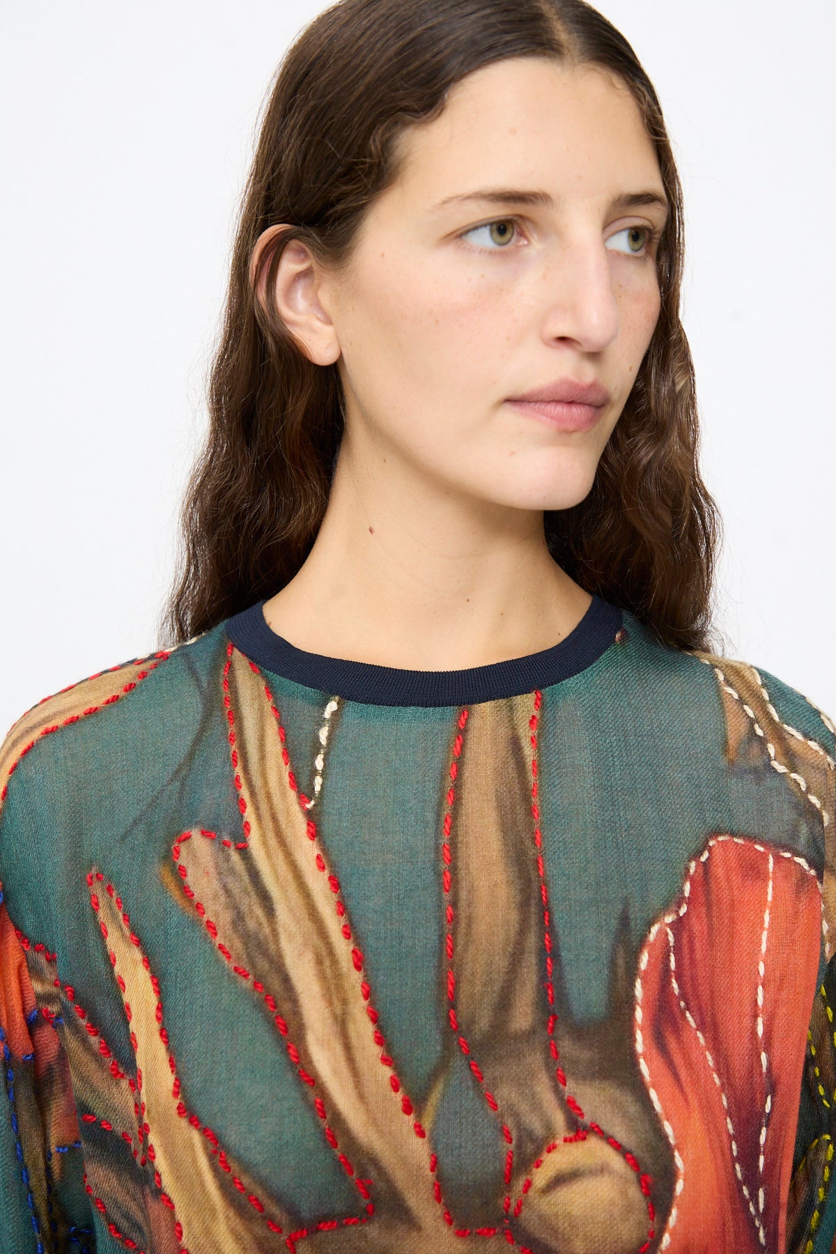 The Bless No. 82 Embroidered Sweater in Dark Brown and Green is a lightweight, floral print wool sweater in shades of green and brown featuring prominent red and white decorative embroidery.